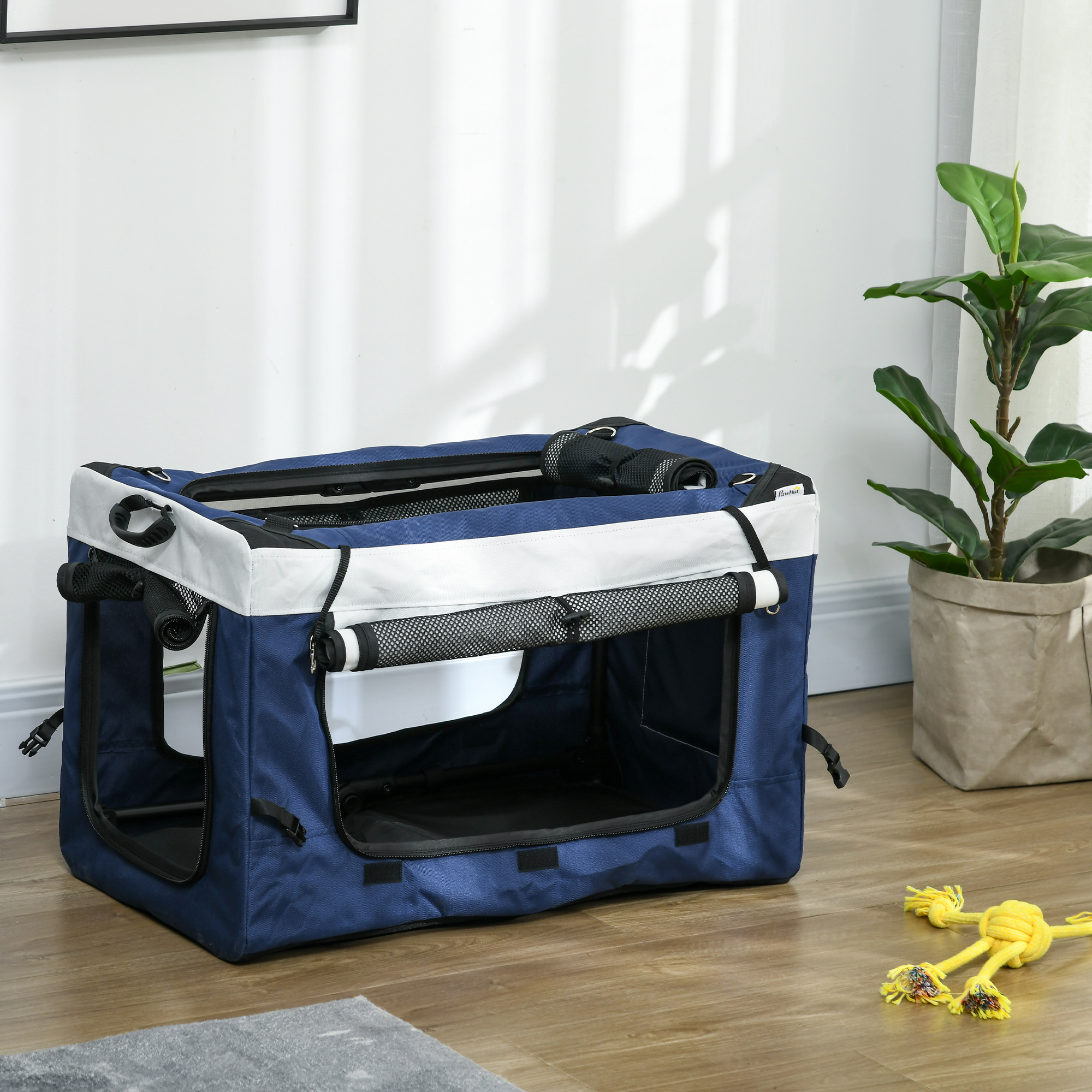 Blau-weiße Hundebox drinnen, mit offener Tür und Zubehör.