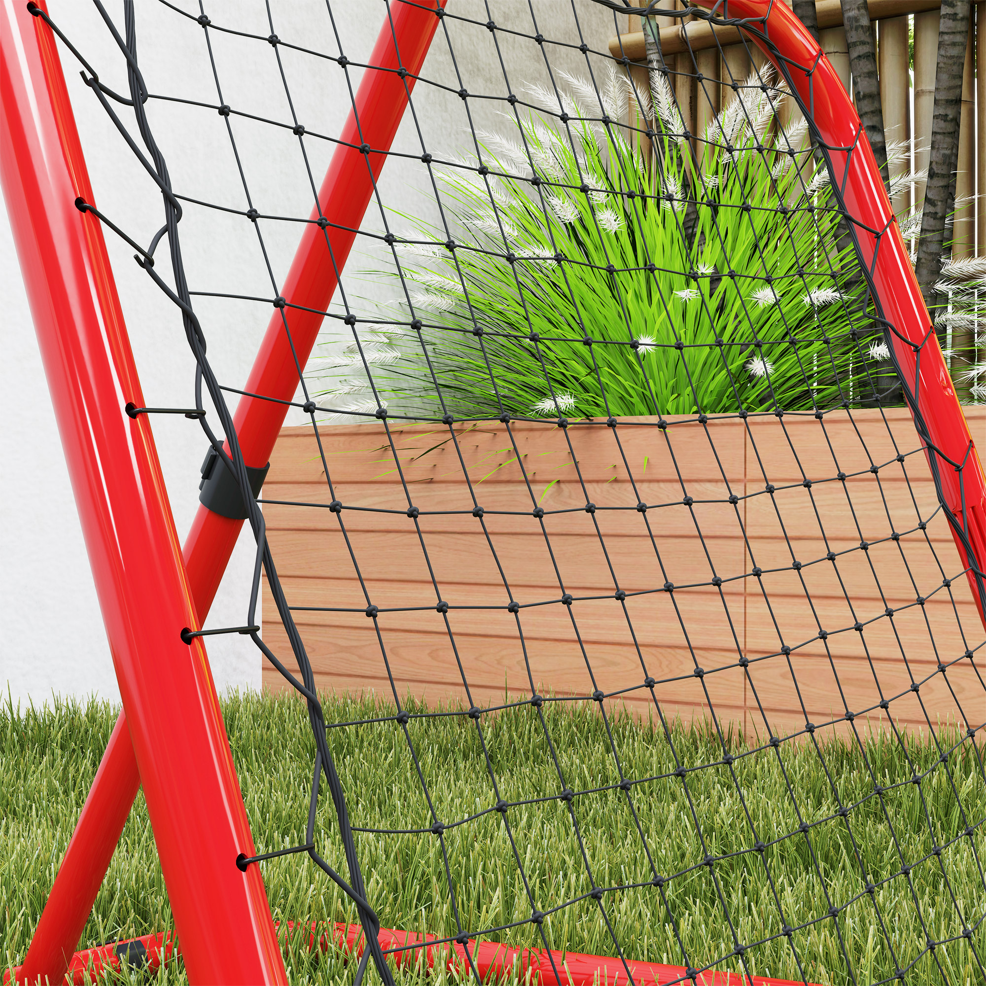 Nahaufnahme des roten Rebounder-Netzes. Schwarzes Netz, roter Rahmen. Grünes Gras und Holzpflanzgefäß im Hintergrund.