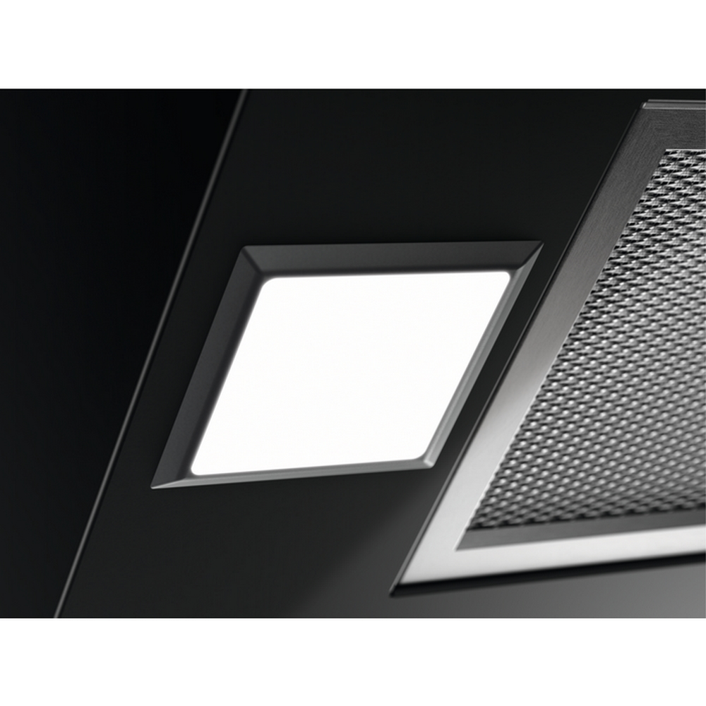 Primer plano de un electrodoméstico negro con luz blanca brillante y una malla metálica.