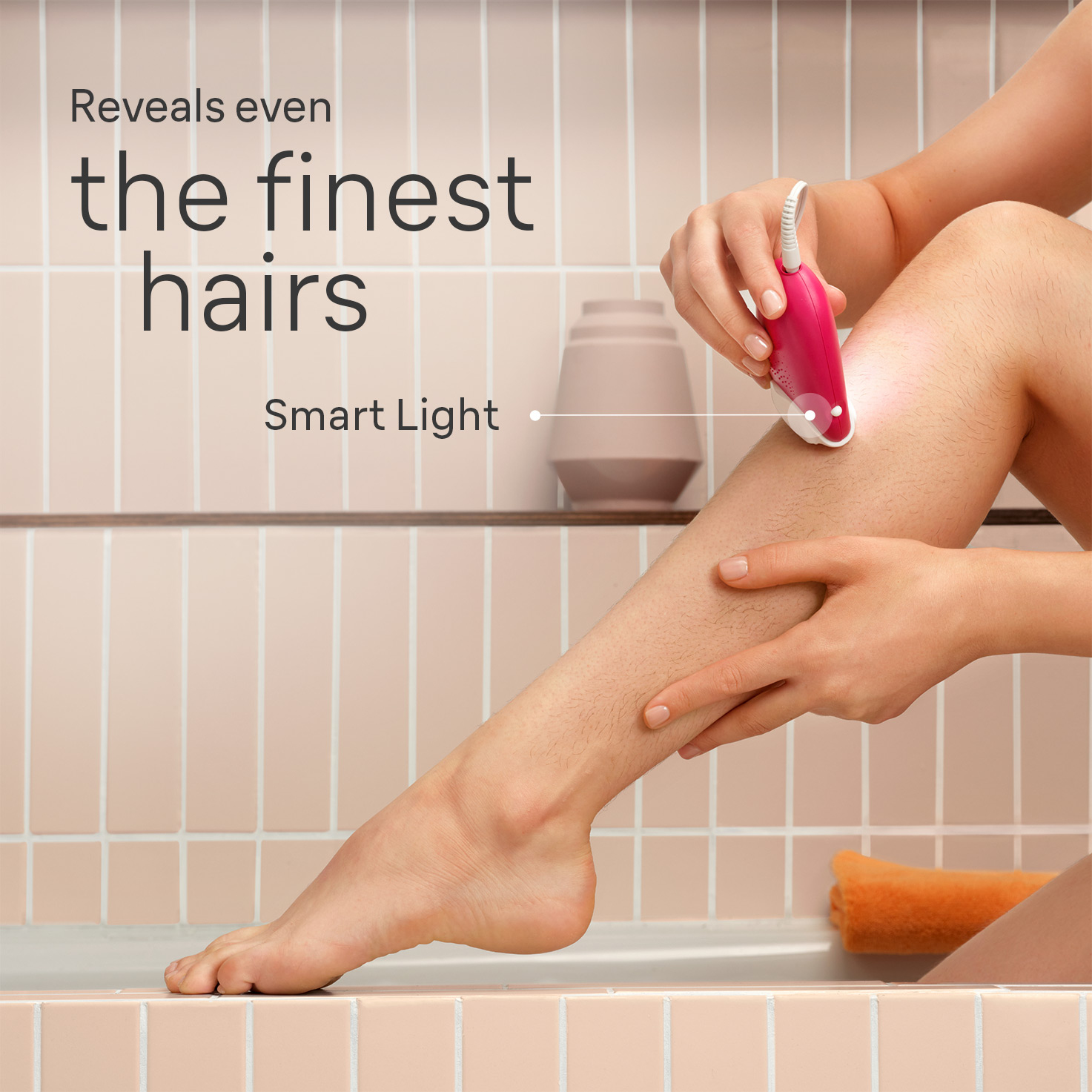 Kobieta używa depilatora na nodze, w łazience. Inteligentne światło jest włączone.