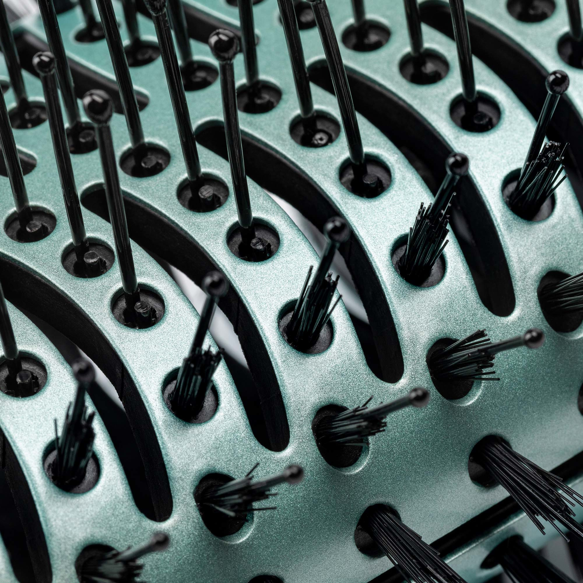 Zbliżenie miętowej szczotki z czarnym włosiem.