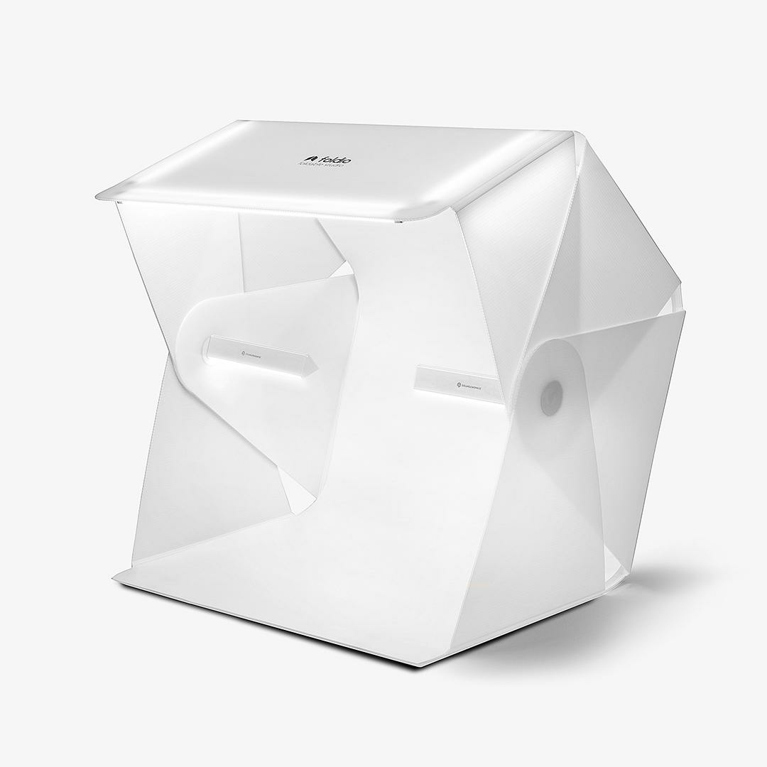 Eine weiße Fotostudiobox, aufgeklappt, mit Innenbeleuchtung.