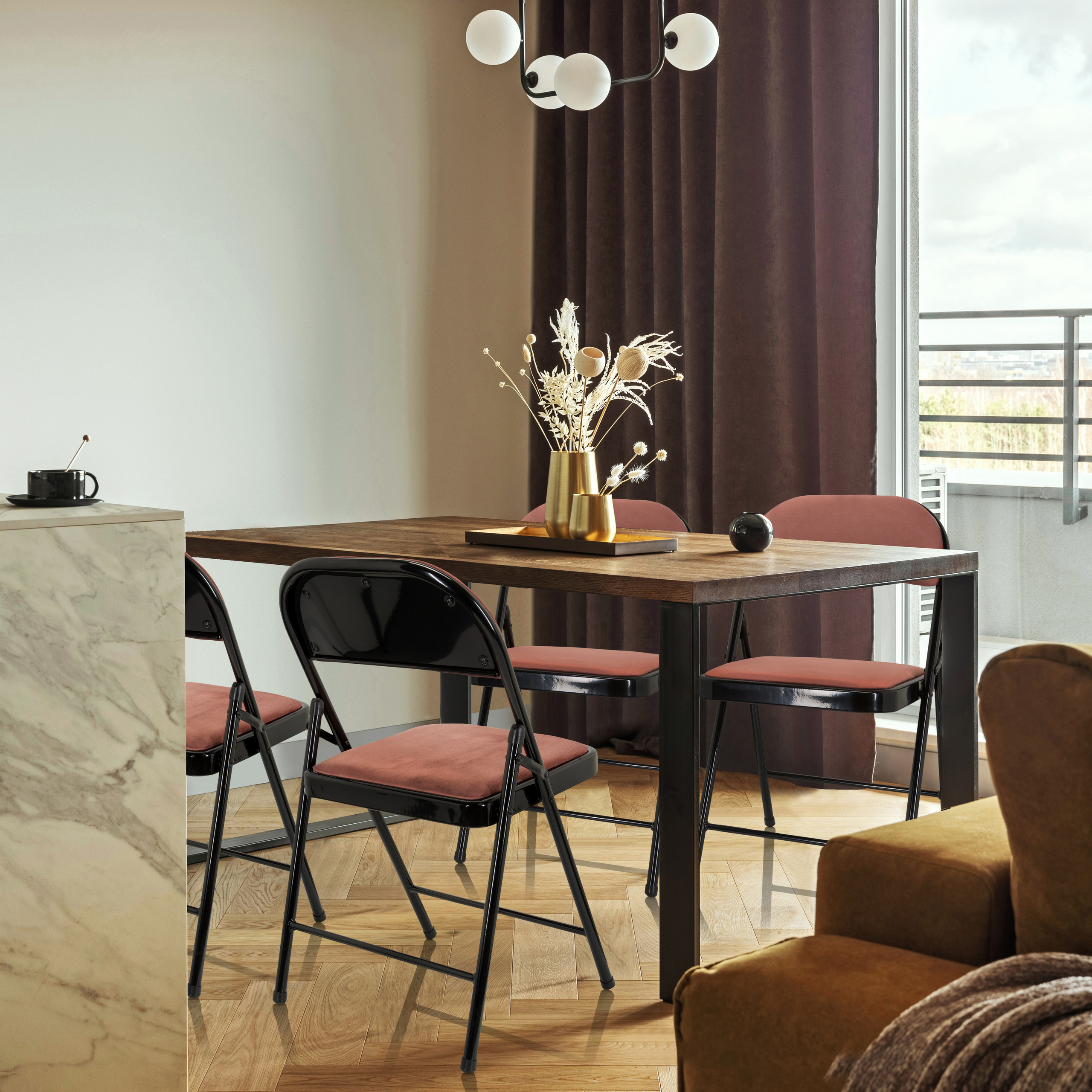 Ein Esszimmer mit Tisch, Stühlen und Dekoration. Rosa Klappstühle sind im Vordergrund.
