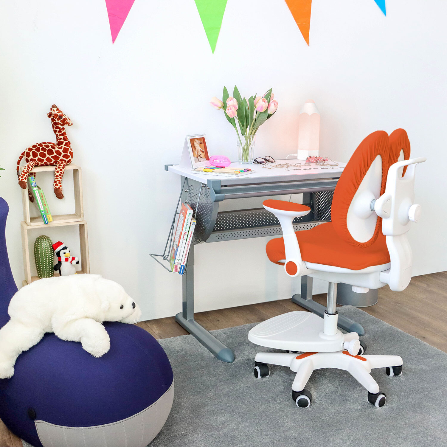 Ein Kinderzimmer mit Schreibtisch, Stuhl und Spielzeug, darunter eine Giraffe und ein Wal.