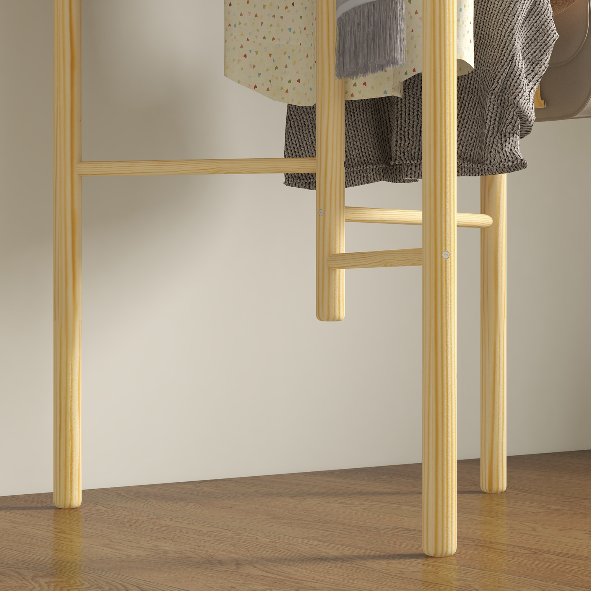 Kleiderständer aus Holz mit Kleidung, die daran hängt, auf einem Holzboden platziert.