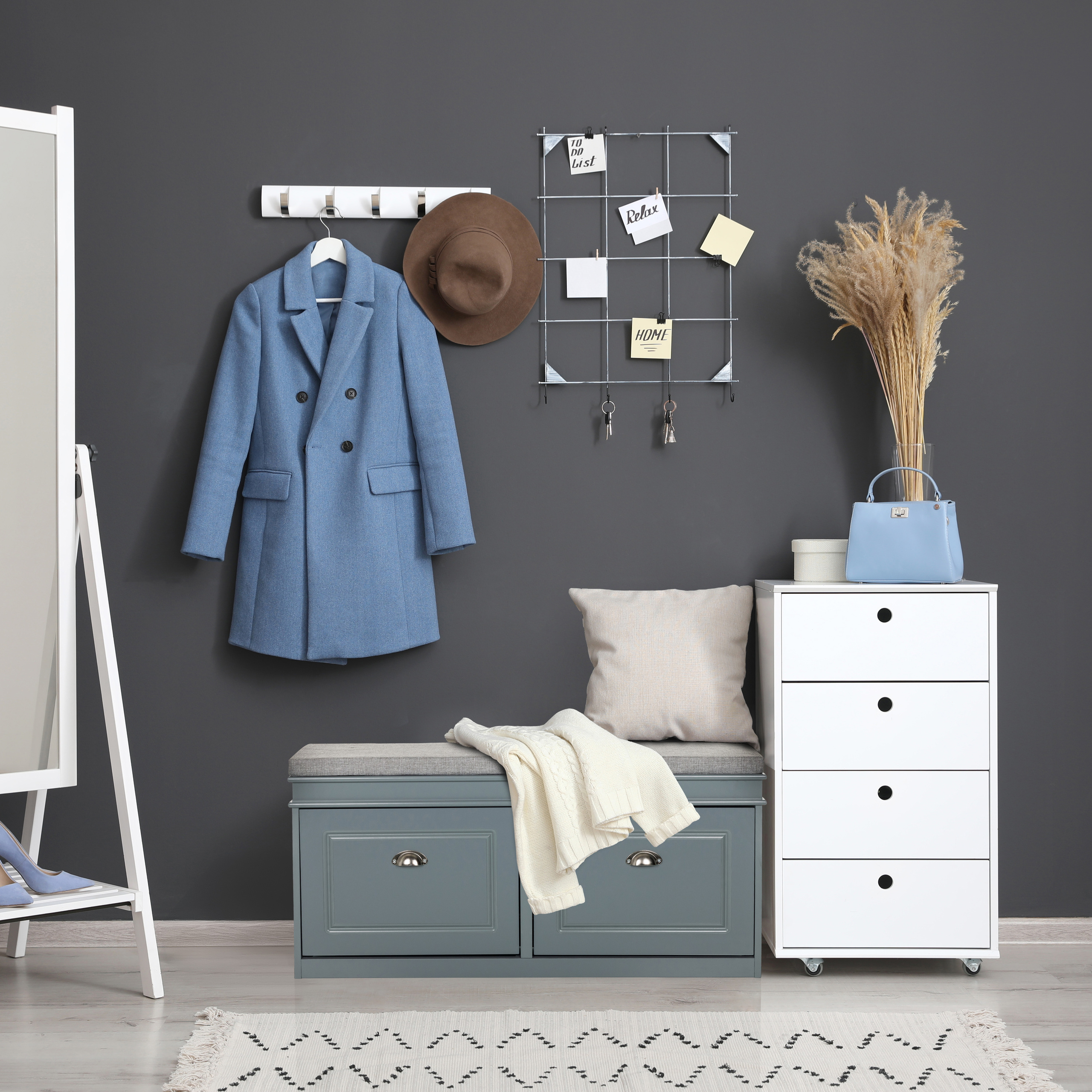 Eingangsbereich mit Mantel, Hut, Spiegel, Schuhschrank und Deko.