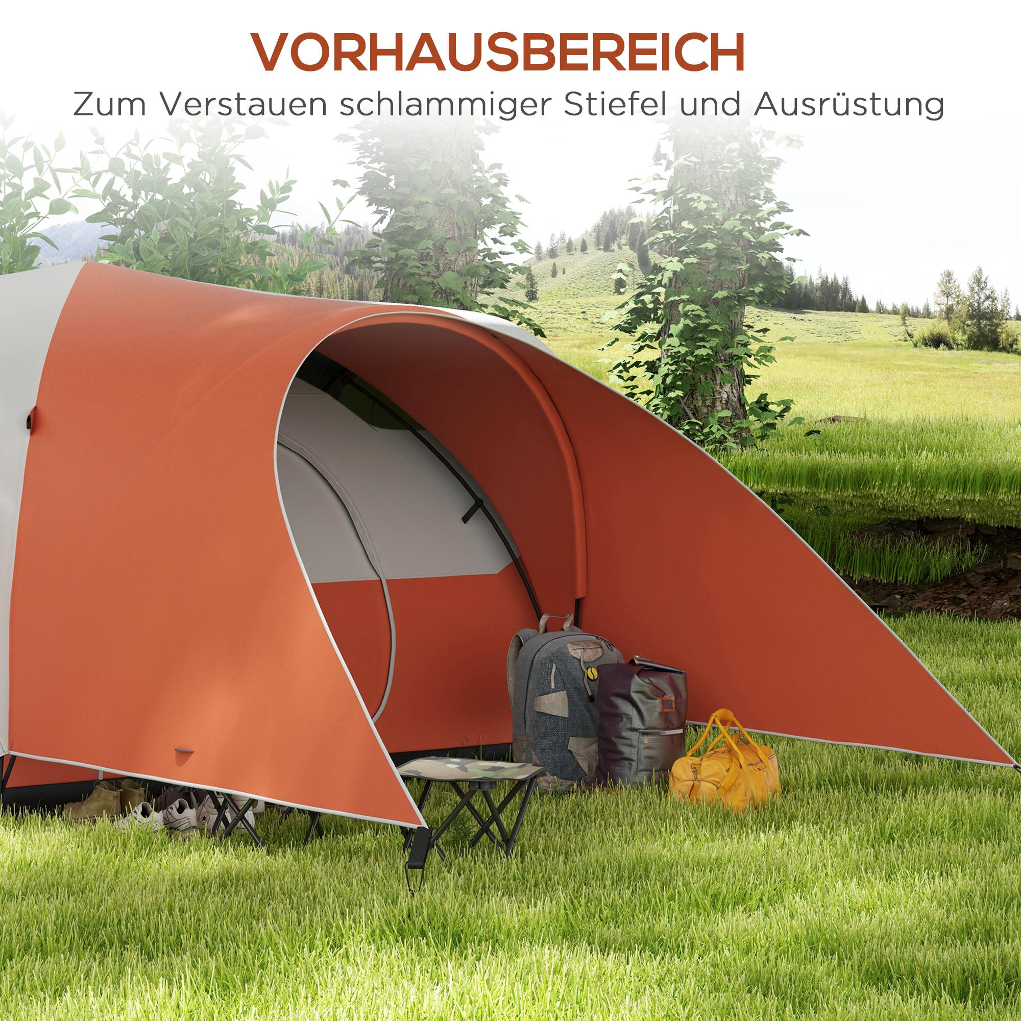 Ein orange-weißes Zelt mit offenem Eingang, ein Rucksack, eine Tasche, ein kleiner Tisch auf Gras.