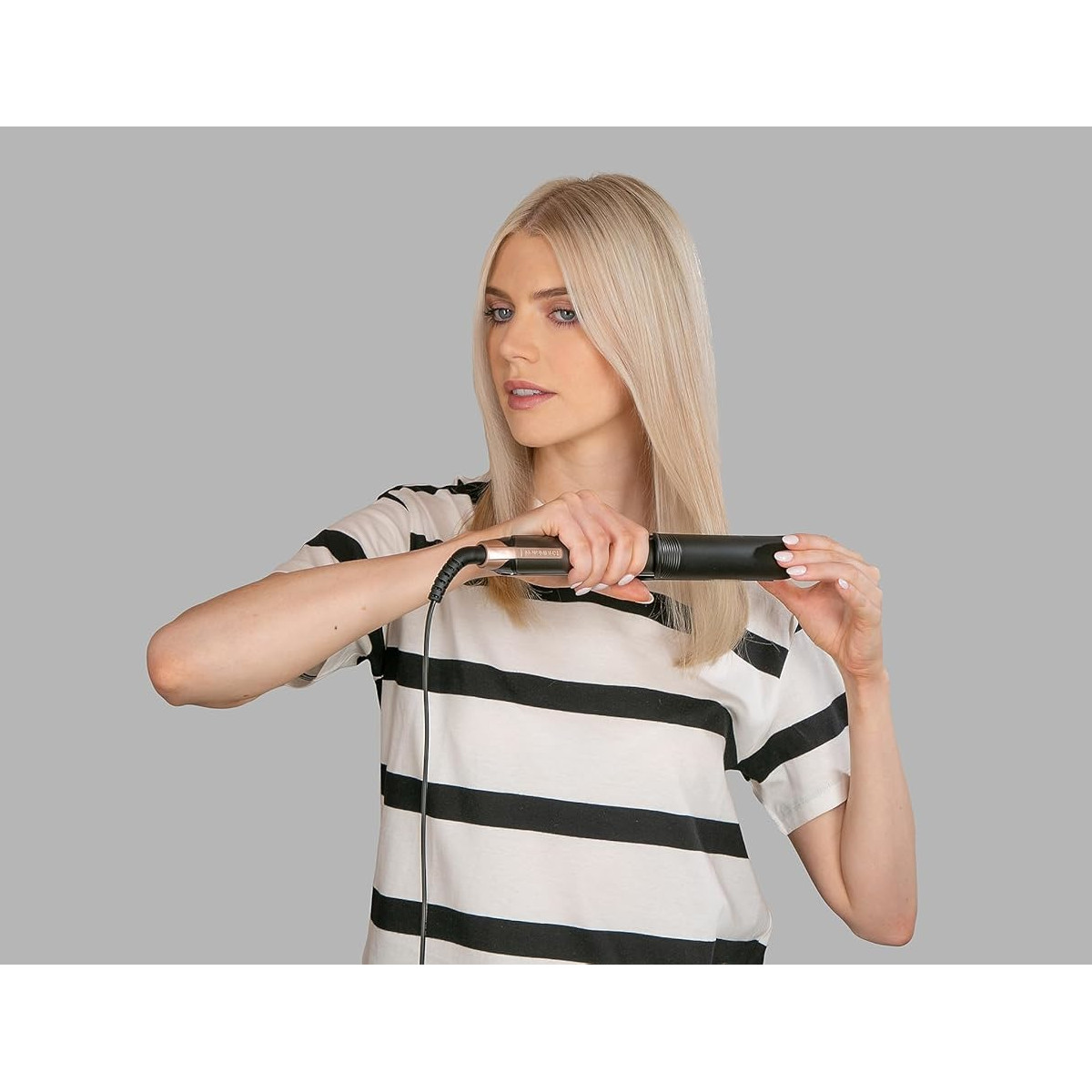 Eine Frau benutzt einen Haarglätter für ihr Haar.
