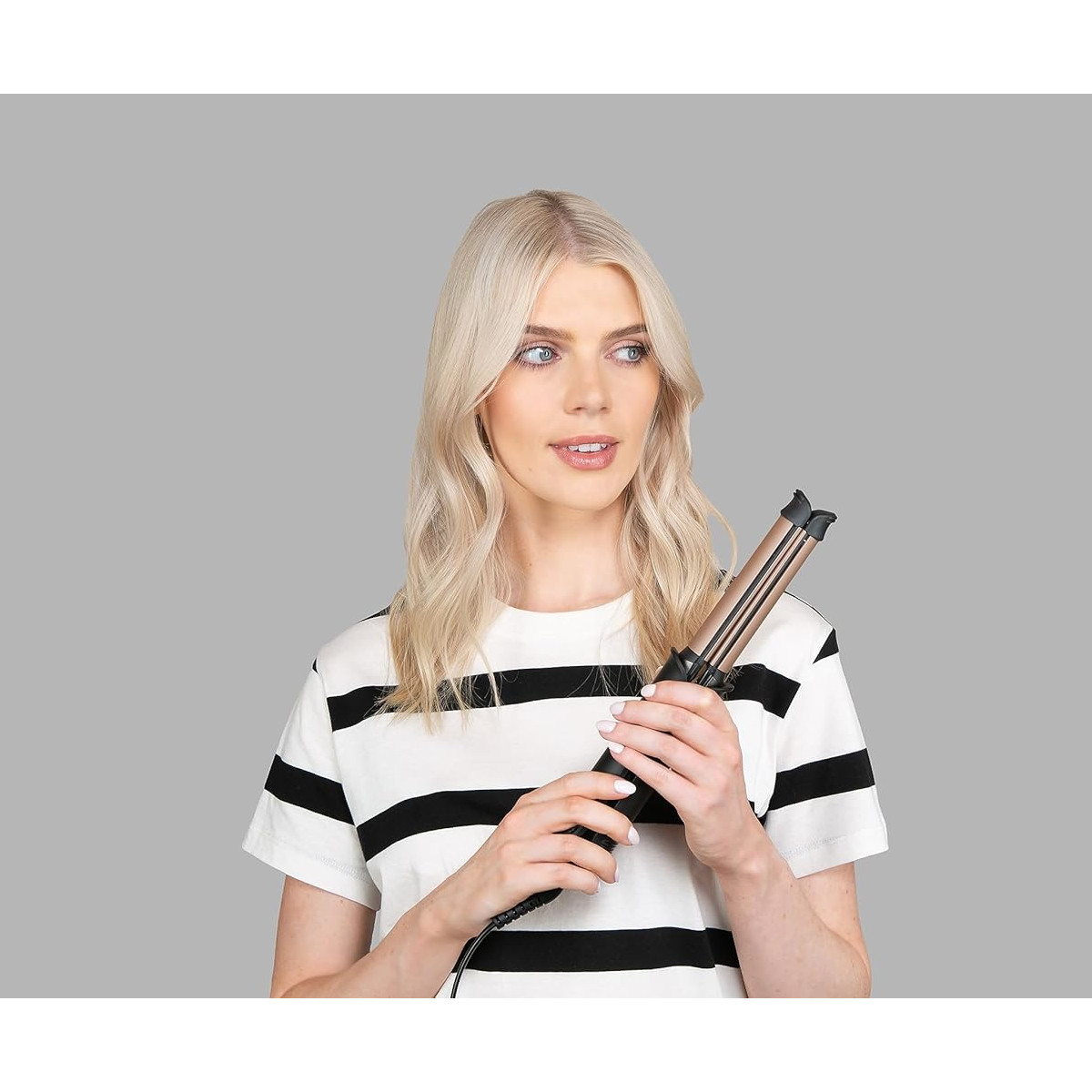 Eine Frau hält einen Haarwellenmacher.