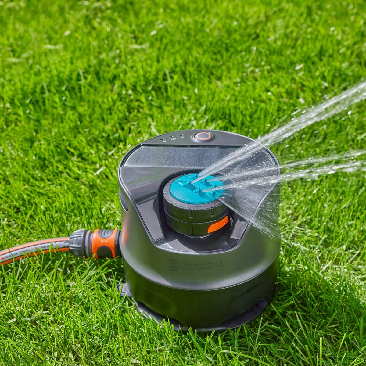 Gardena smart water control in uso. L'irrigatore sta innaffiando l'erba verde. Getto d'acqua visibile.