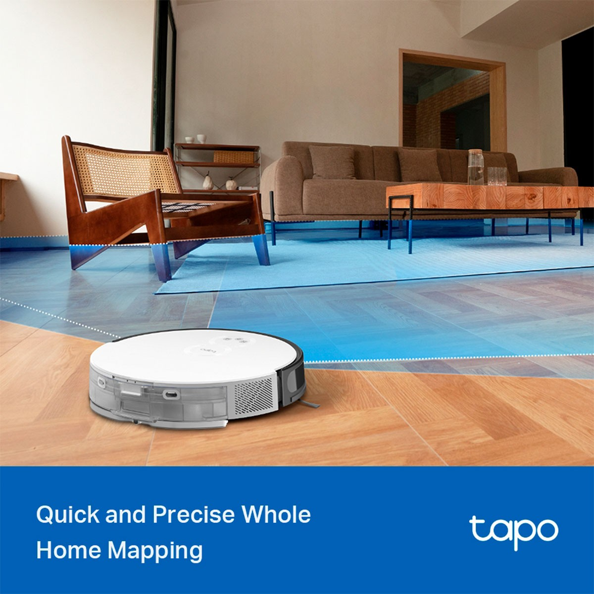 Odkurzacz robot na drewnianej podłodze, z sofą i krzesłem w tle.