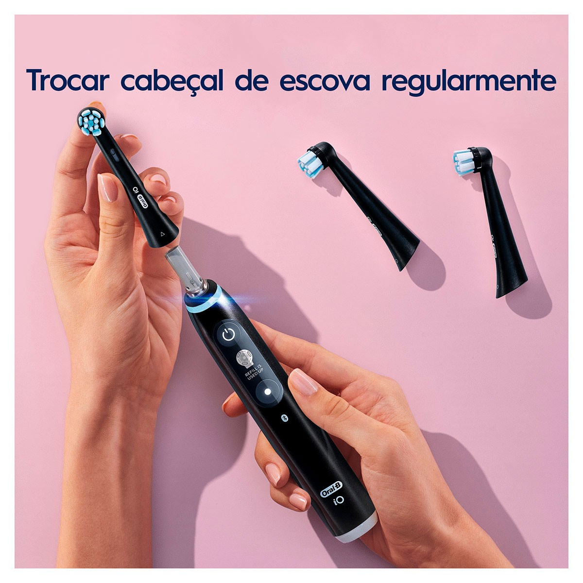 Donna che tiene lo spazzolino da denti. Due testine di ricambio a destra. Testo: cambiare le testine.