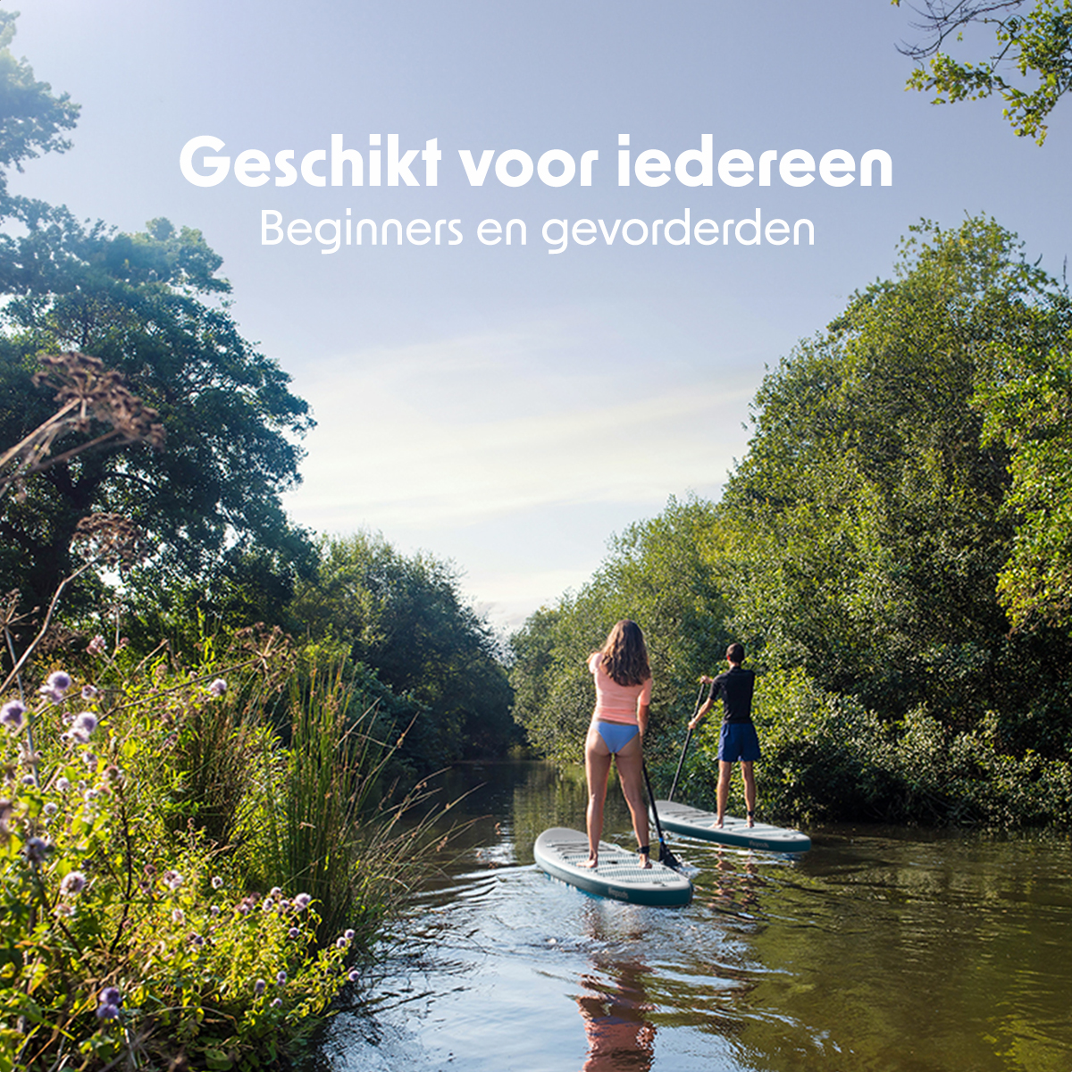 Twee mensen aan het paddleboarden op een rivier, omringd door groene bomen en bladeren.