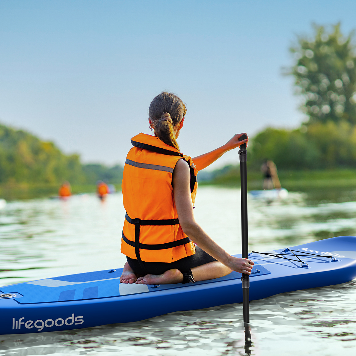 Eine Frau in einer orangefarbenen Schwimmweste paddelt mit einem blauen Paddleboard auf dem Wasser.