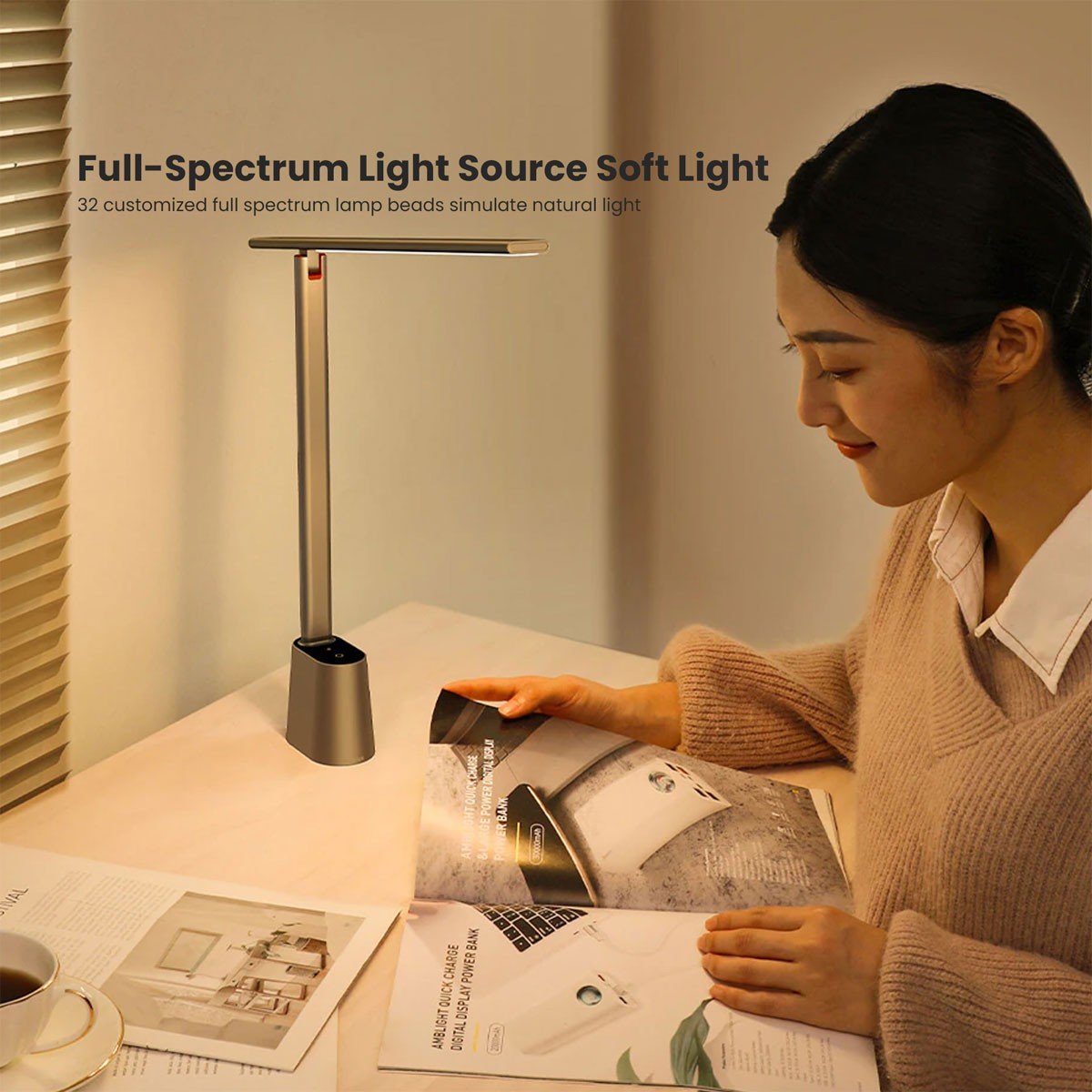 Kobieta czyta w pobliżu lampy biurkowej. Na biurku papiery, filiżanka i telefon. Lampa daje miękkie światło.