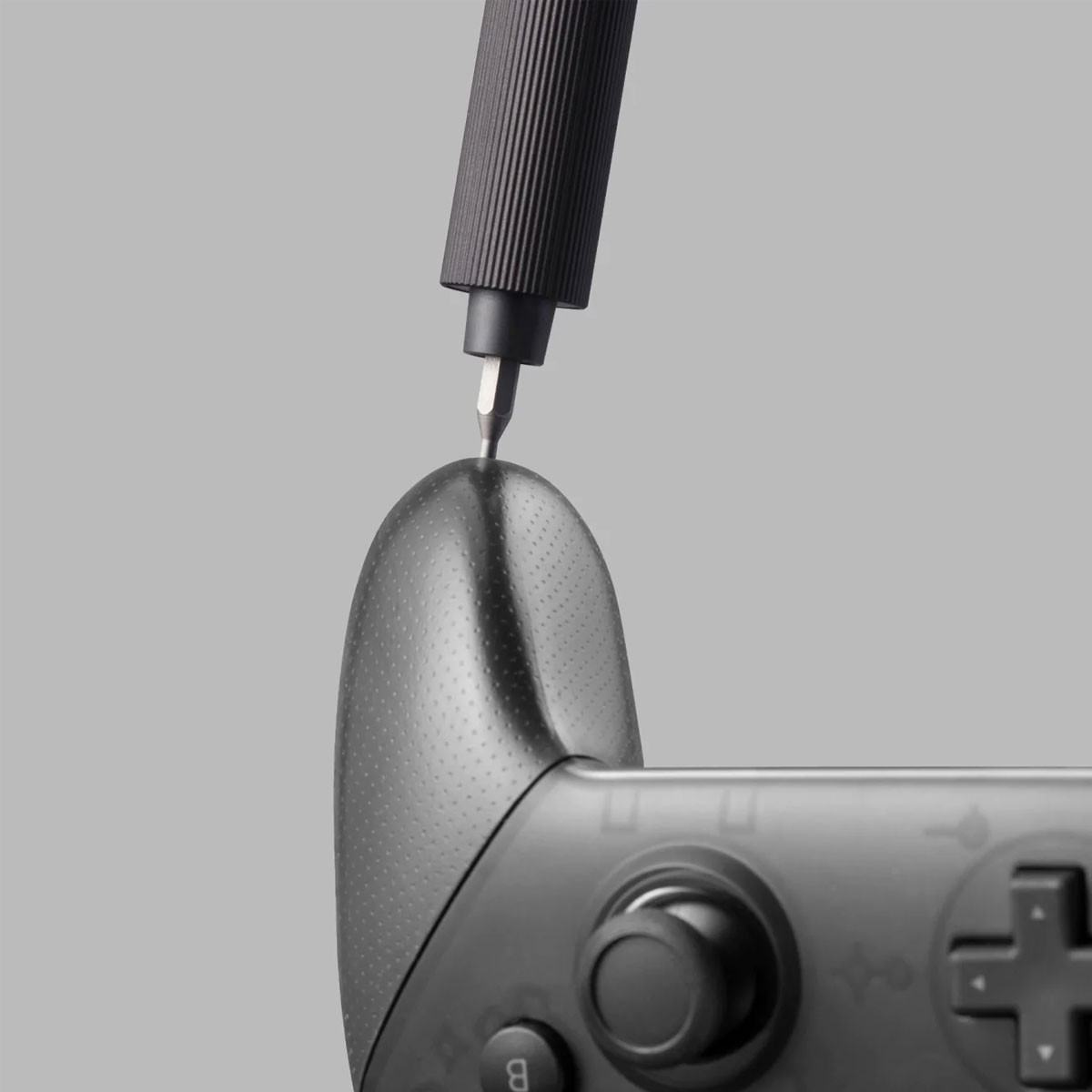 Ein Schraubendreher wird an einem Gamecontroller verwendet.