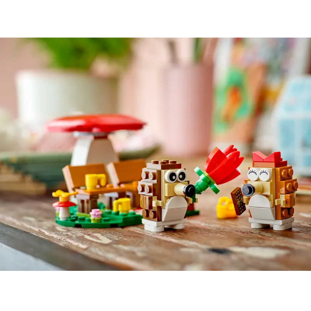 Dwie figurki jeży Lego na pikniku. Jeden trzyma kwiat, drugi napój.