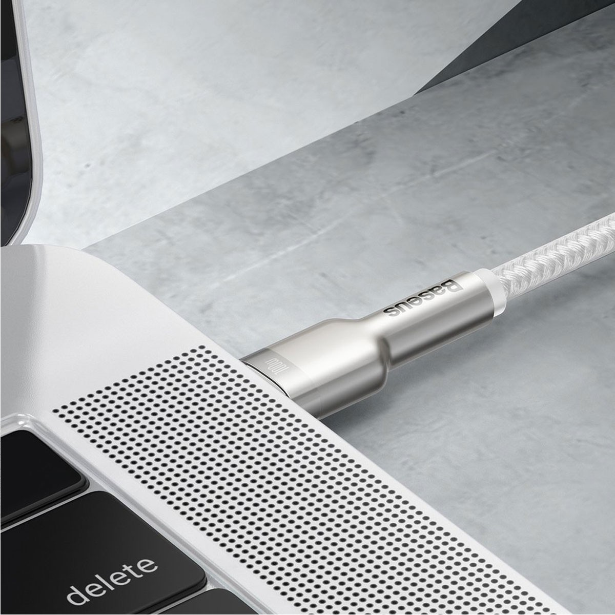 Cable USB-C conectado a una laptop. La marca Baseus es visible.