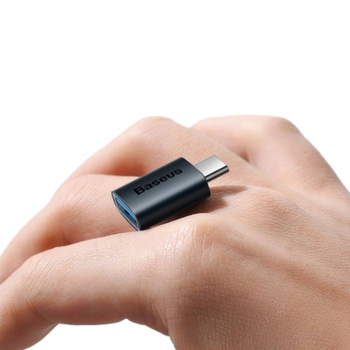 Dłoń trzymająca małą, czarną przejściówkę USB-C. Widoczne logo Baseus.