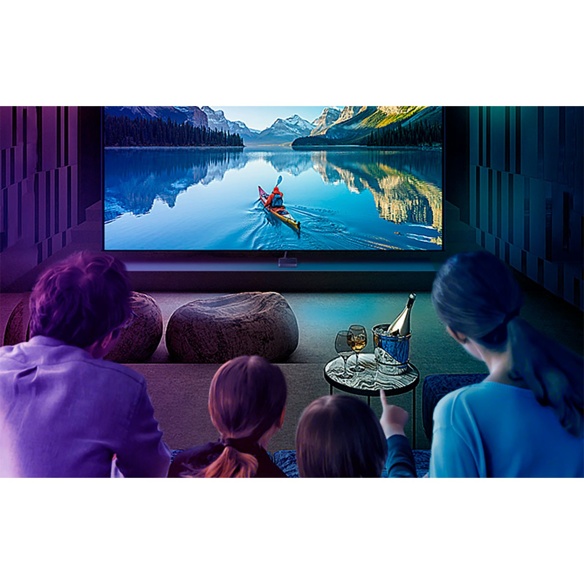 Rodzina ogląda duży telewizor z jeziorem i kajakarzem.