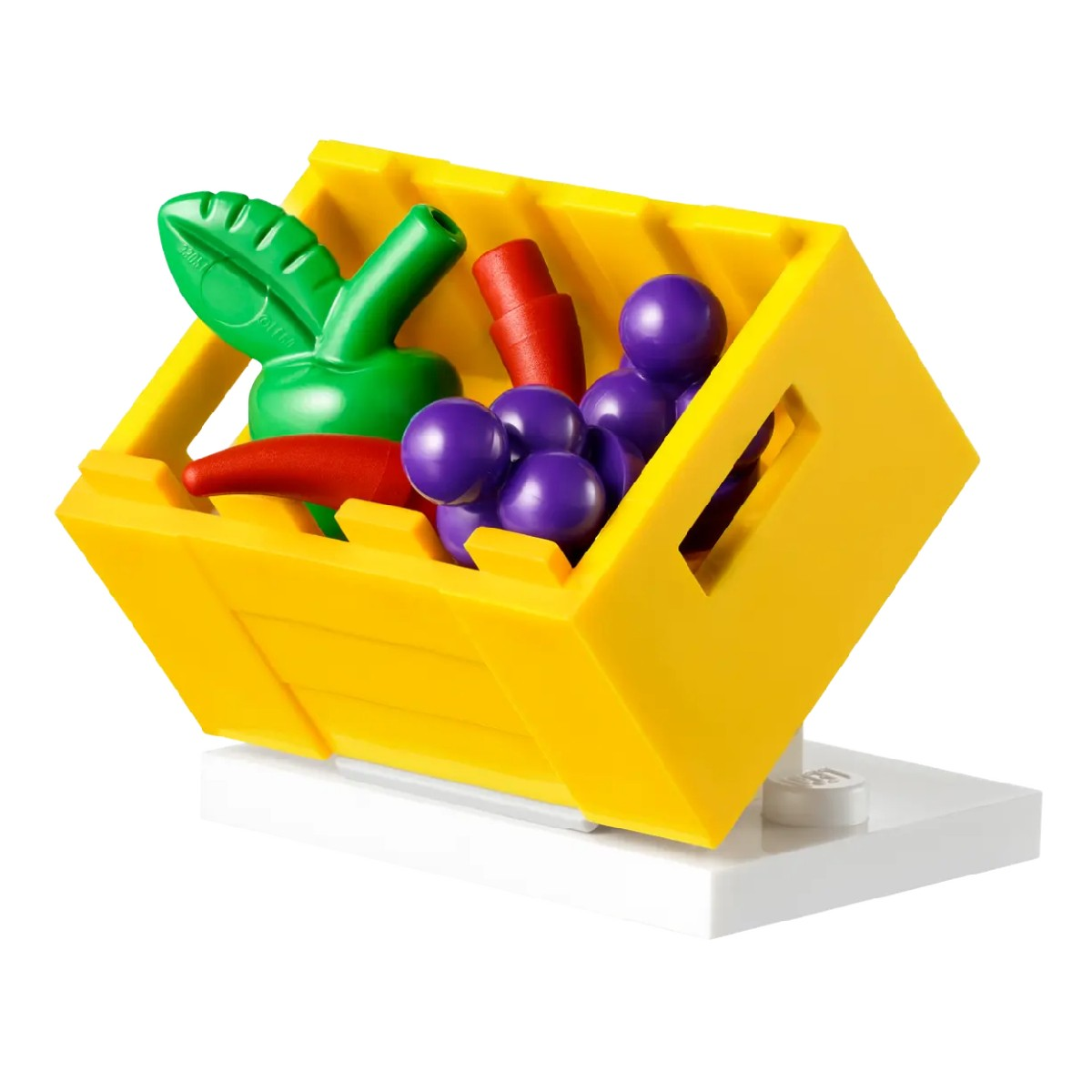 Scatola Lego con frutta. Oggetti verdi, rossi e viola all'interno. Base bianca.