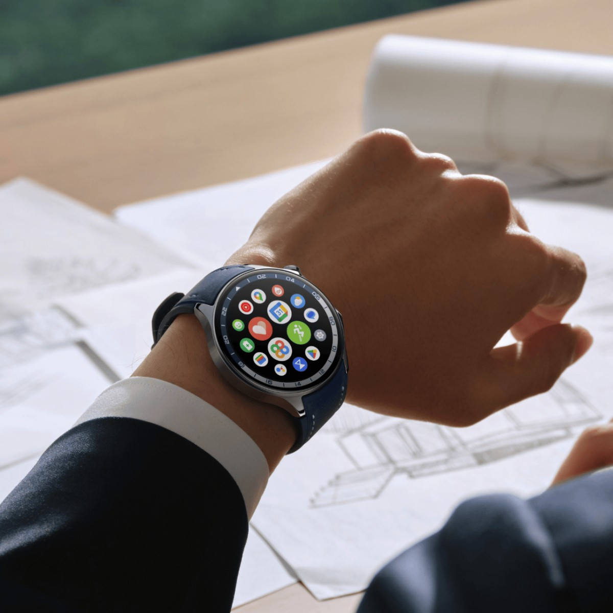 Mężczyzna noszący smartwatch z ikonami aplikacji. Zegarek ma niebieski pasek.