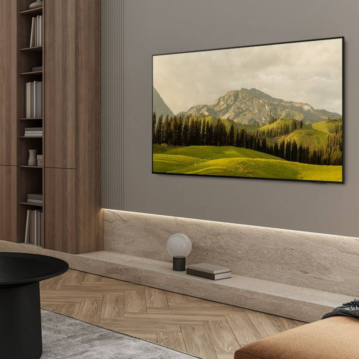 Telewizor na ścianie w pokoju z zielonymi polami i górami.