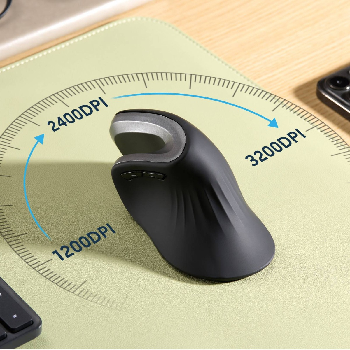 Mouse ergonomico nero con impostazioni DPI multiple. Il mouse è su un tappetino verde con un telefono nell'angolo.