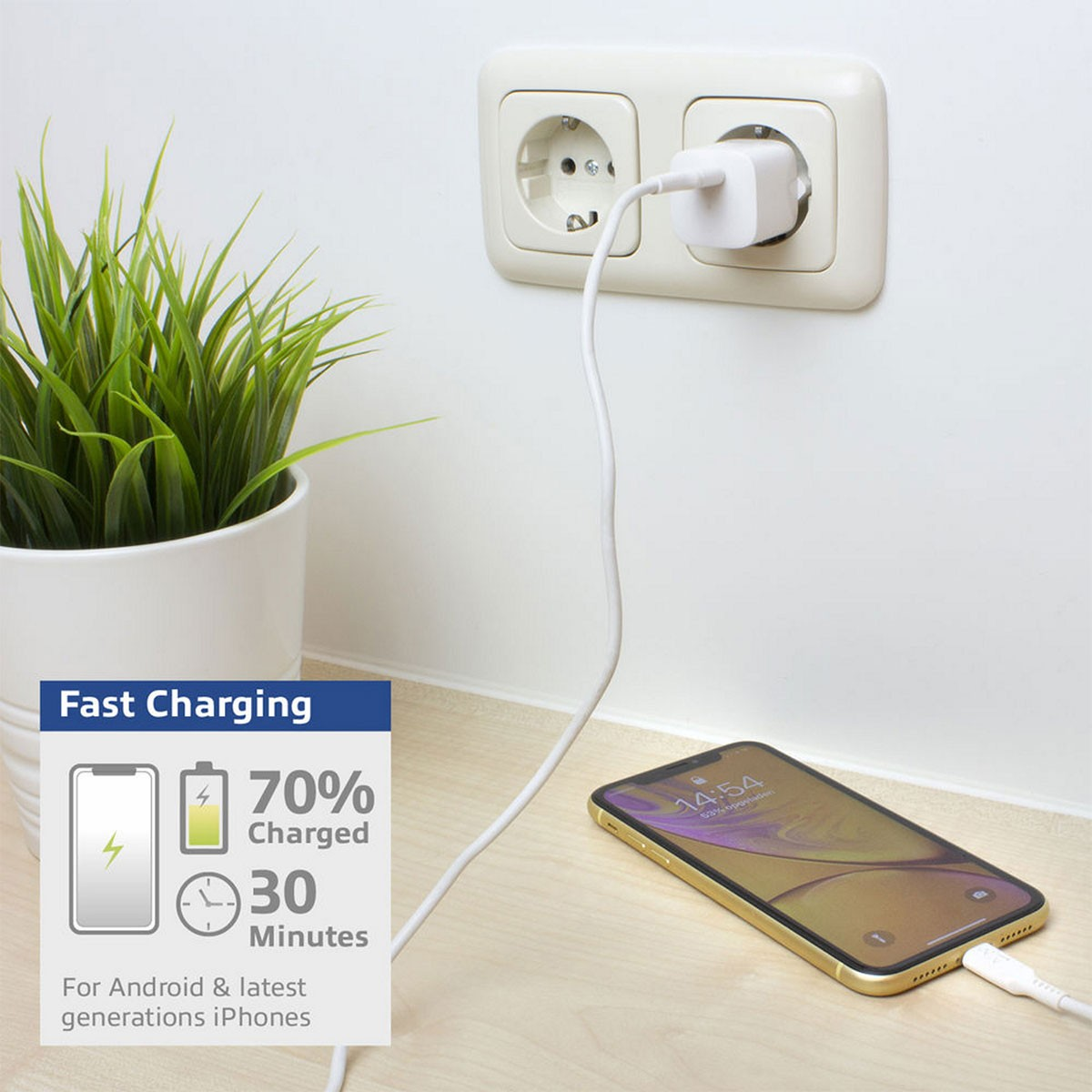 Teléfono cargando con infografía de carga rápida, enchufado a una toma de corriente, con planta.
