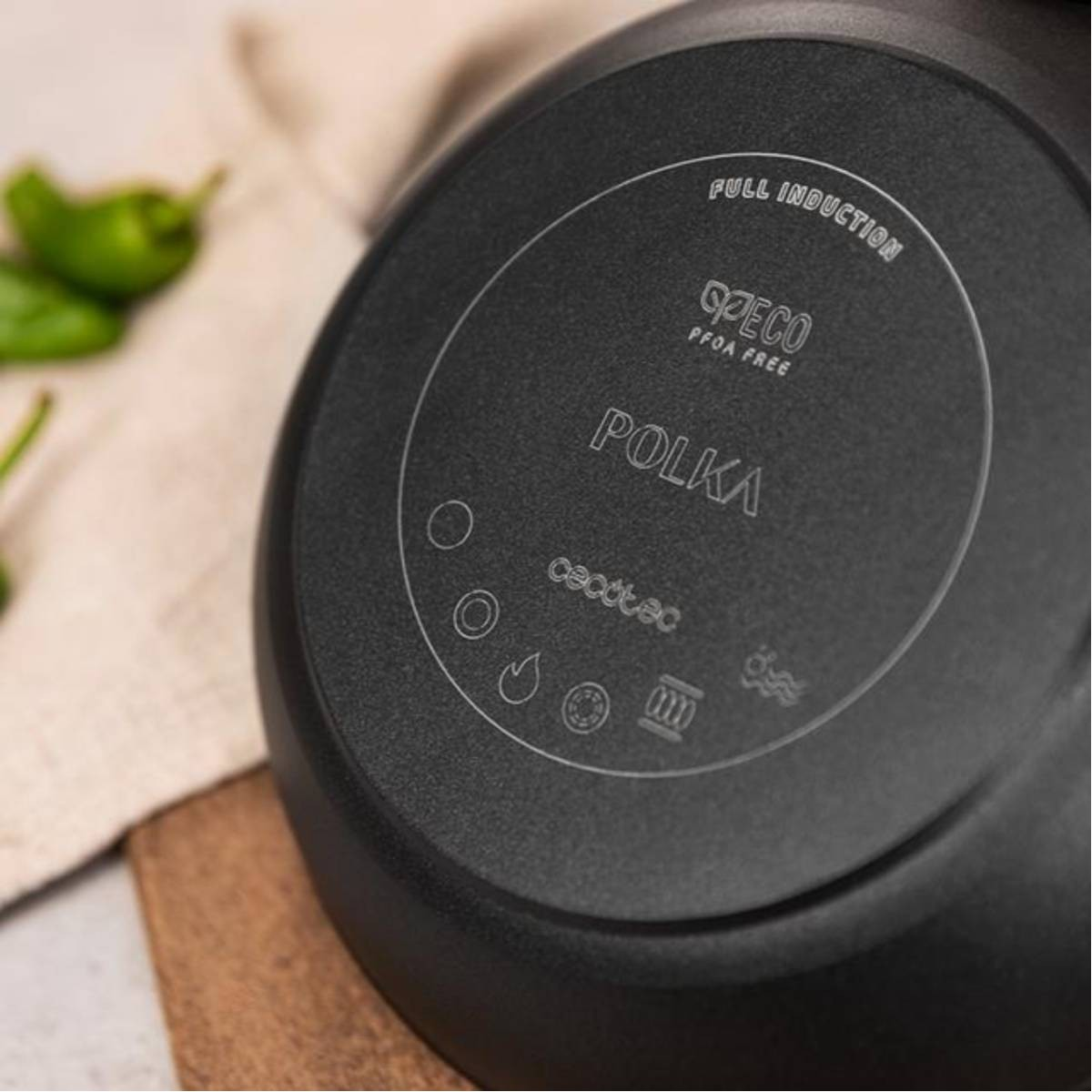 Spód czarnej patelni POLKA z symbolami gotowania i tekstem: PFOA FREE, FULL INDUCTION.