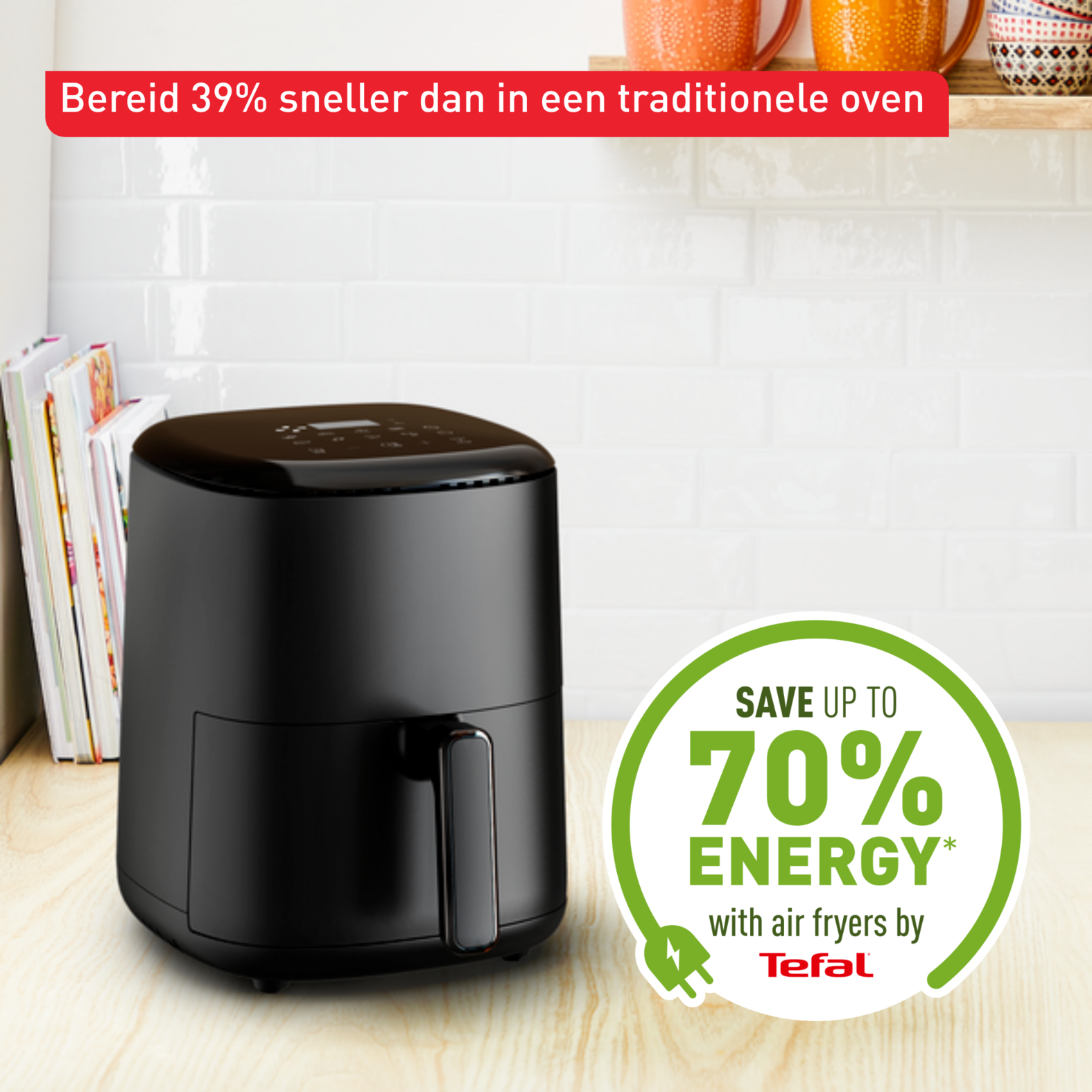 Friggitrice ad aria Tefal nera su una superficie in legno. Testo: 'Risparmia fino al 70% di energia'. Sfondo di piastrelle bianche.