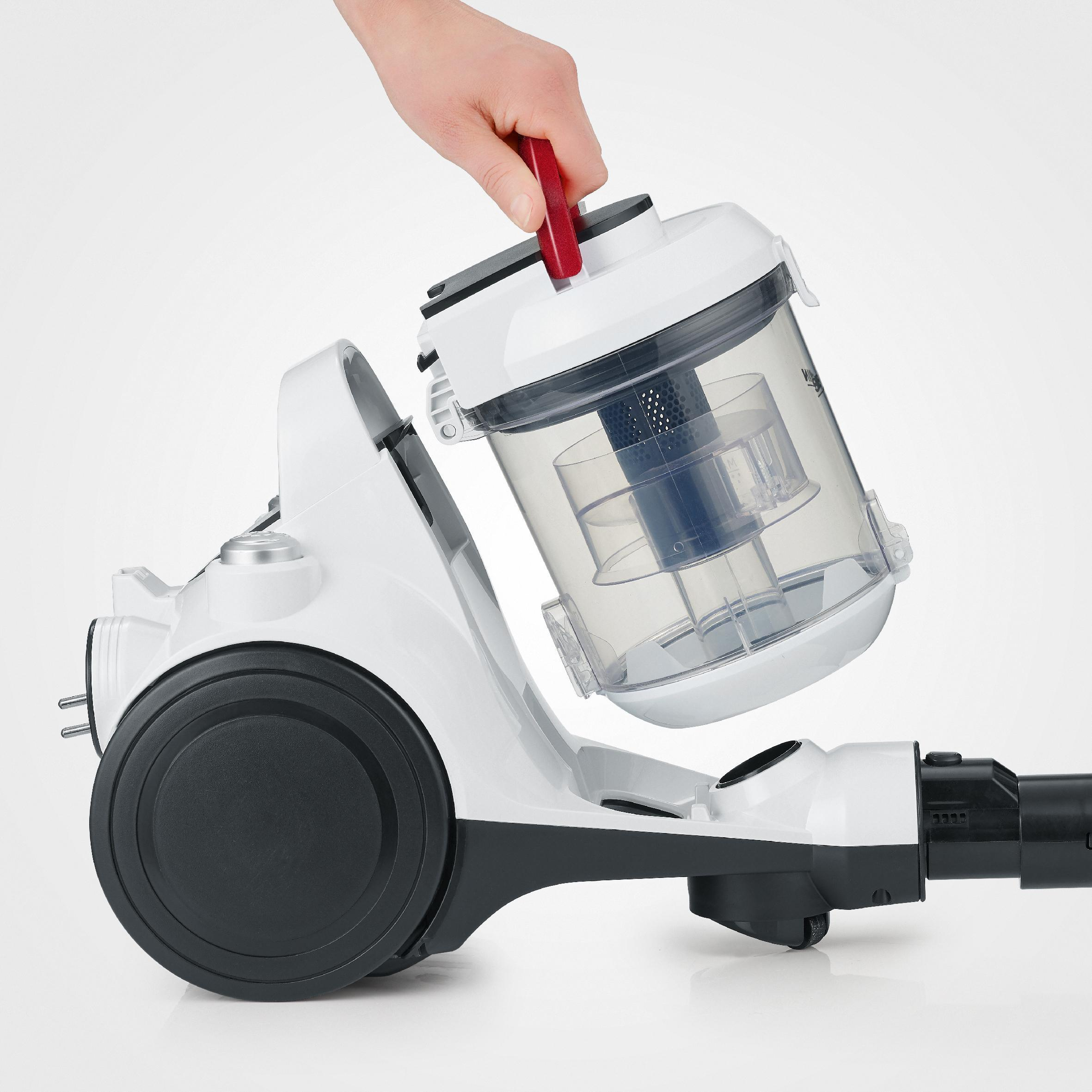 Ręka wyjmuje przezroczysty pojemnik z białego odkurzacza.