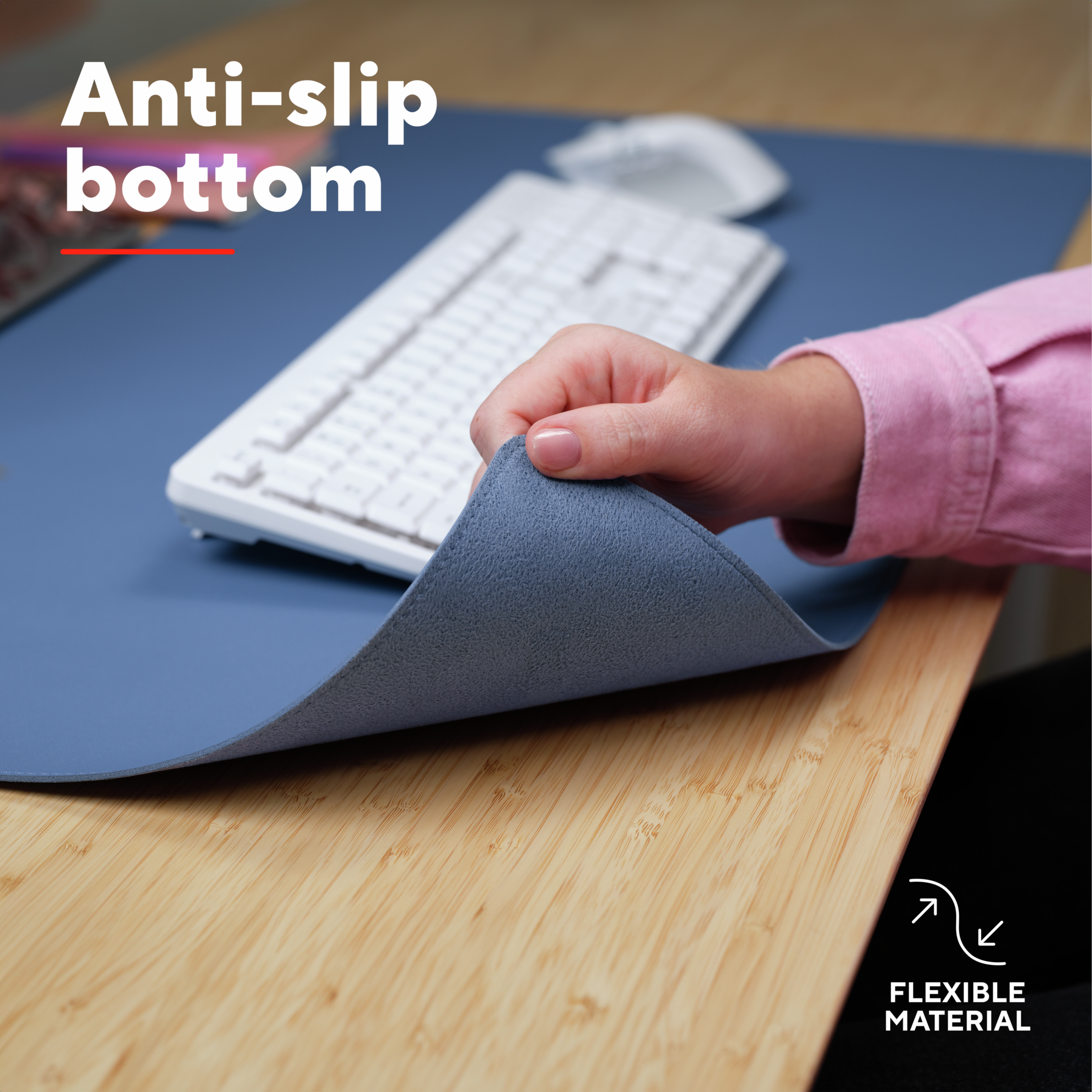 Een hand tilt de hoek van een blauwe bureaumat op. Tekst zegt 'Anti-slip onderkant' en 'Flexibel materiaal'.