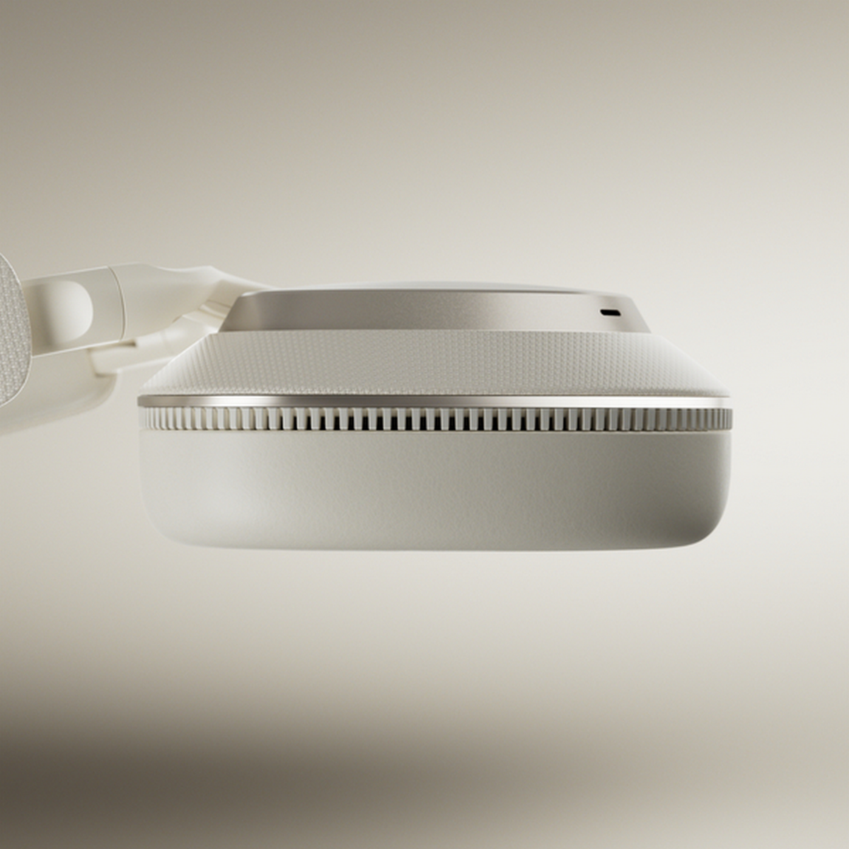 Słuchawki w kolorze ecru, widok z góry. Beżowe tło.