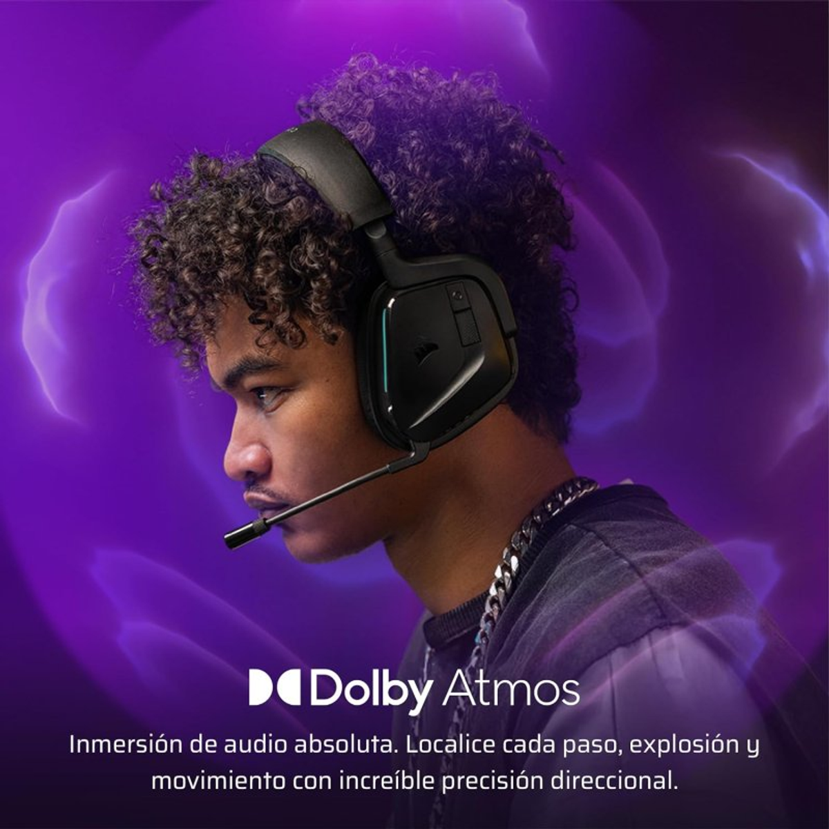 Młody mężczyzna w słuchawkach, fioletowe tło, tekst Dolby Atmos.