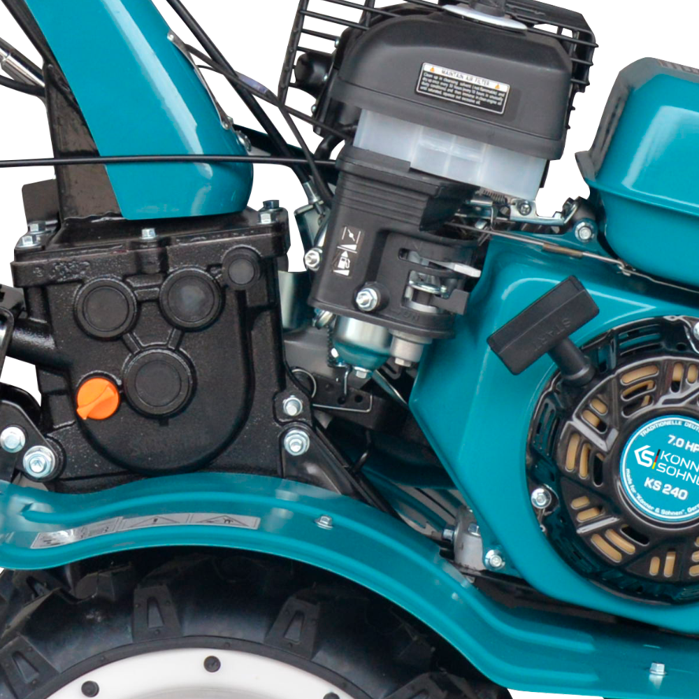 Zbliżenie silnika glebogryzarki w kolorze niebiesko-czarnym z widocznymi elementami.