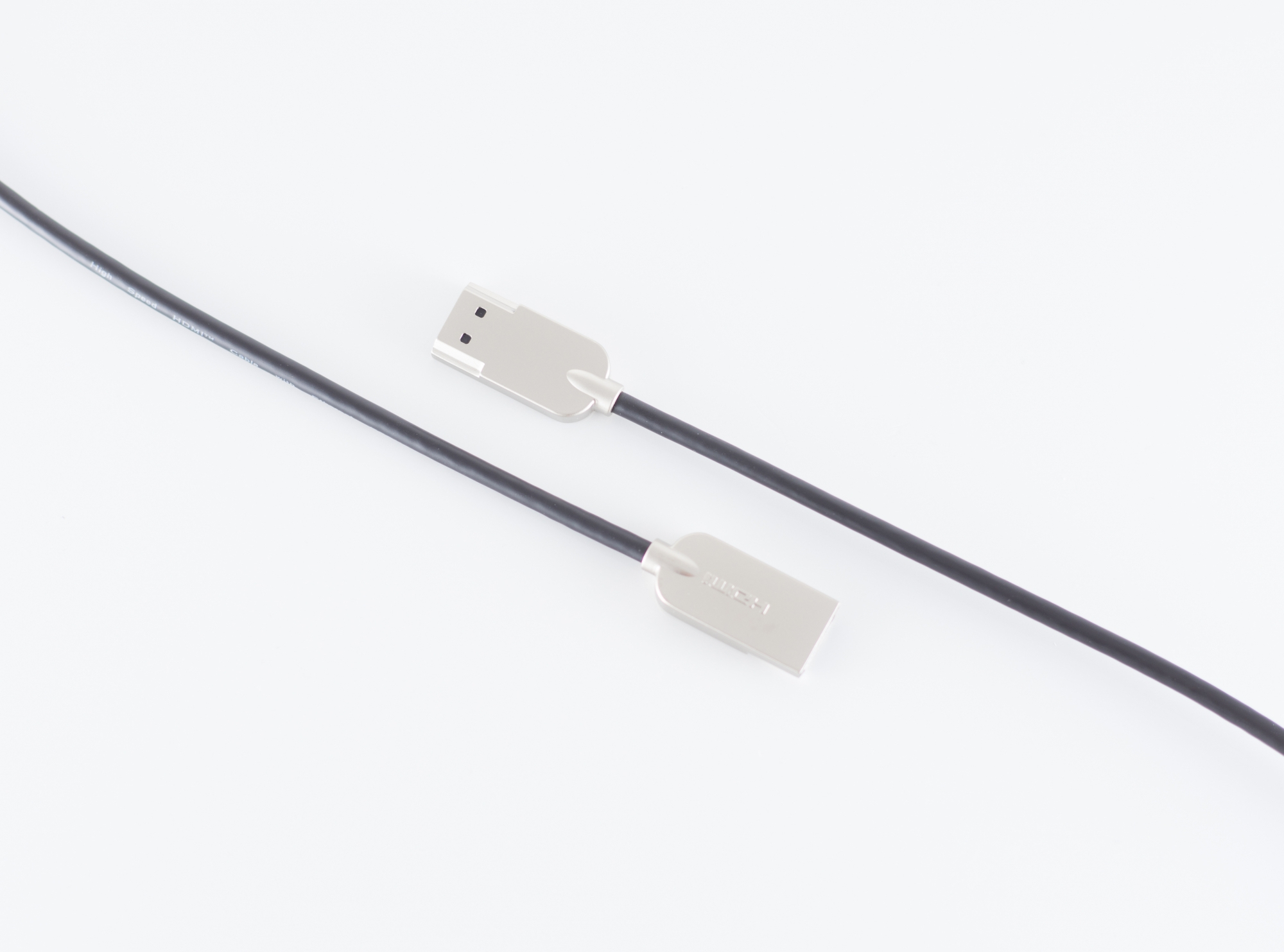 Zwei USB-Kabel mit silbernen Steckern auf weißem Hintergrund, schwarzes Kabel.