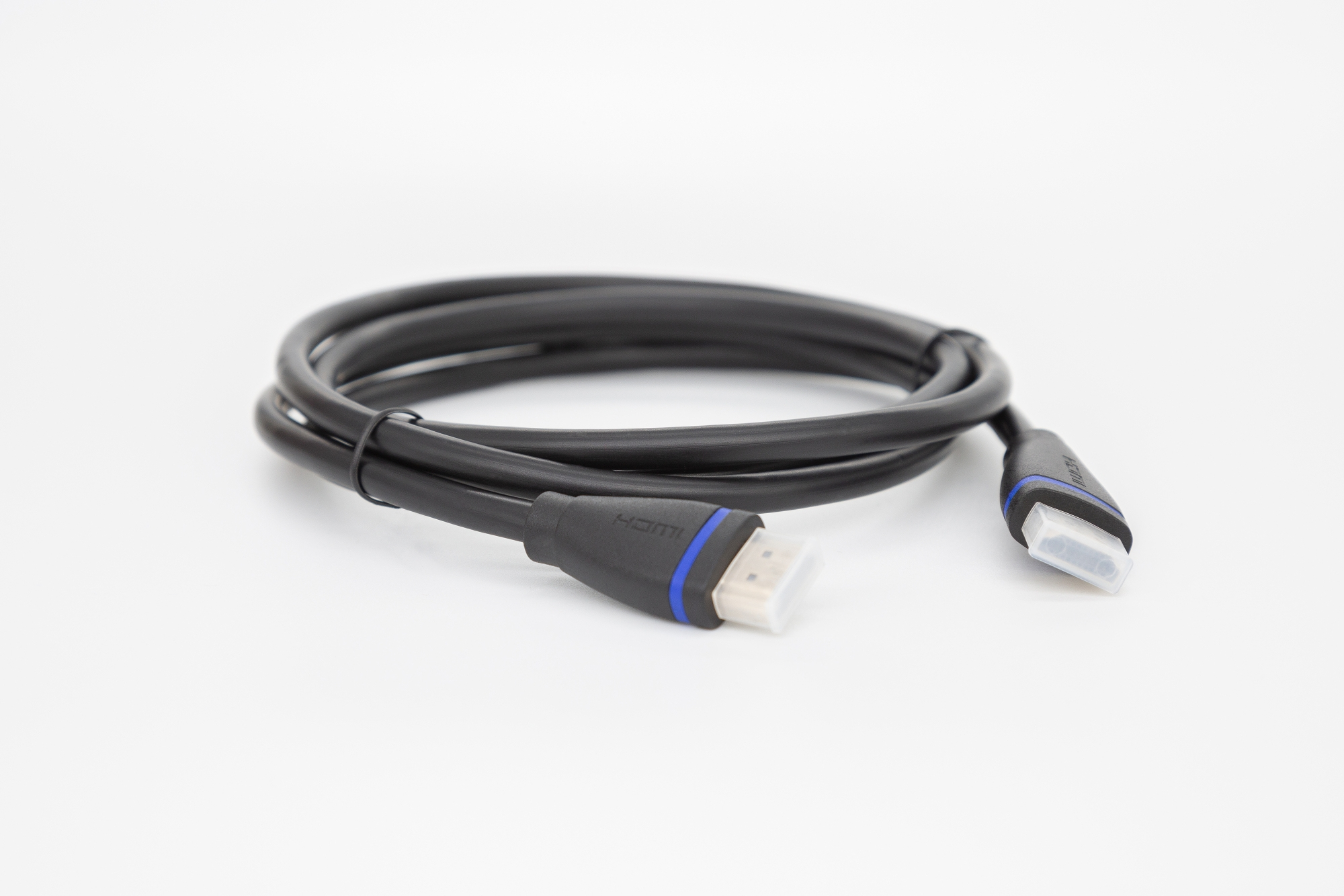 Schwarzes HDMI-Kabel. Das Kabel ist auf einer weißen Oberfläche aufgerollt. Anschlüsse haben blaue und weiße Akzente.