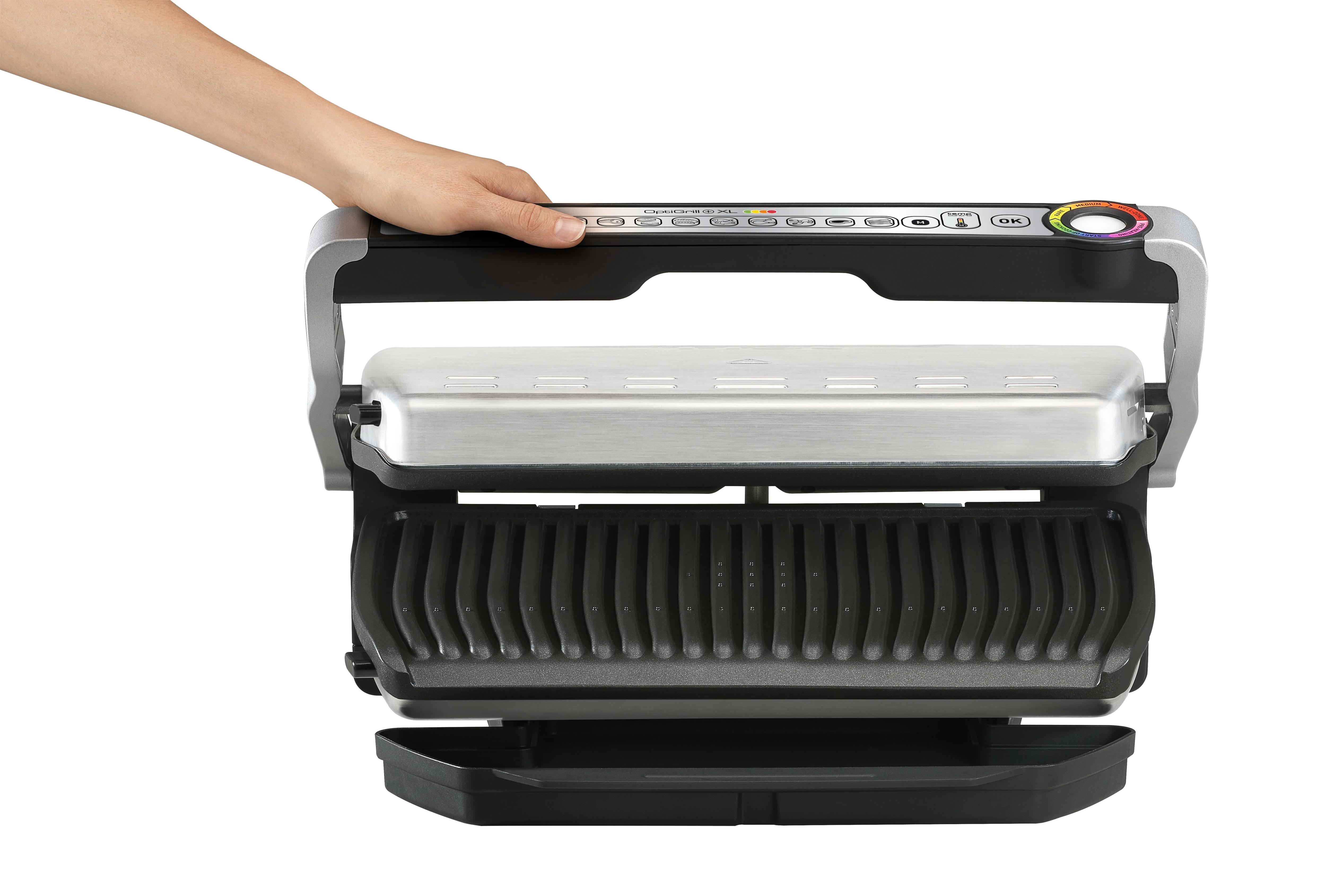 Hand hält silbernen und schwarzen Grill, offen. Schwarze Basis. Weißer Hintergrund.