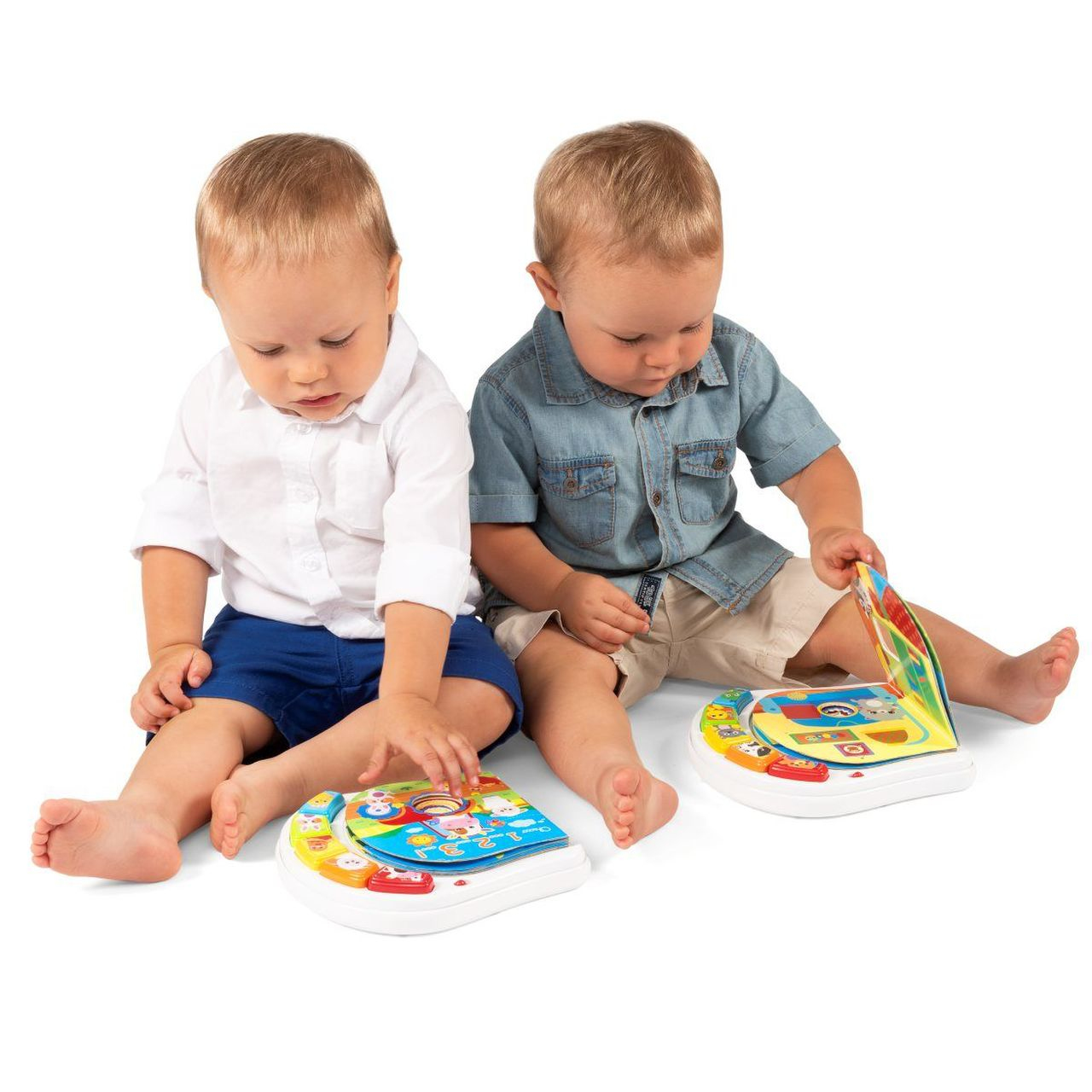 Zwei Babys mit Spielzeugbüchern. Weißer Hintergrund.
