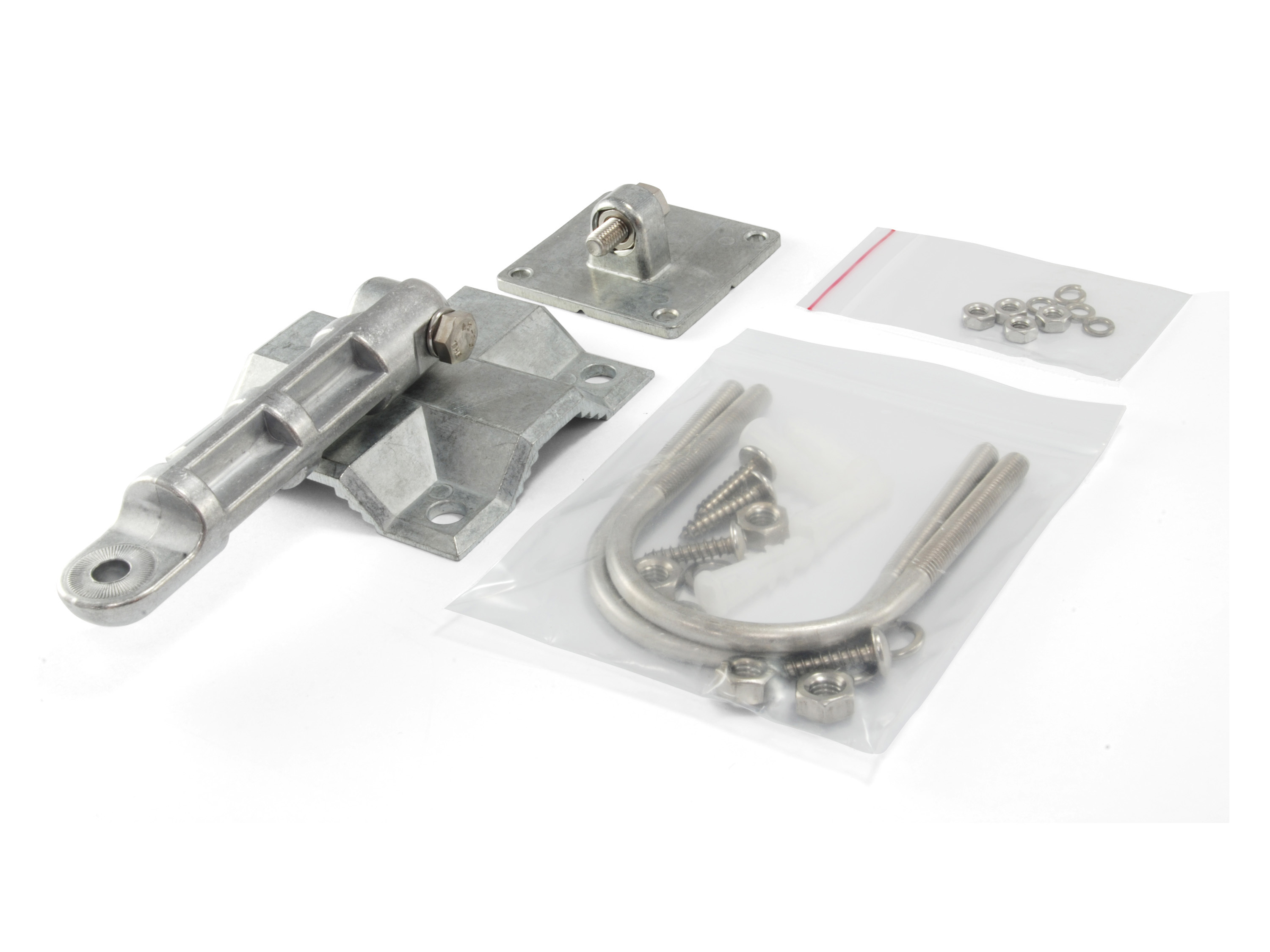 Różne srebrne elementy montażowe, śruby i przezroczysta plastikowa torba na białym tle.