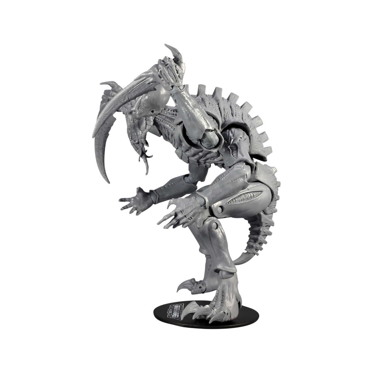 Graue Tyraniden-Figur mit sichelförmiger Klinge, auf schwarzem Sockel, weißer Hintergrund.