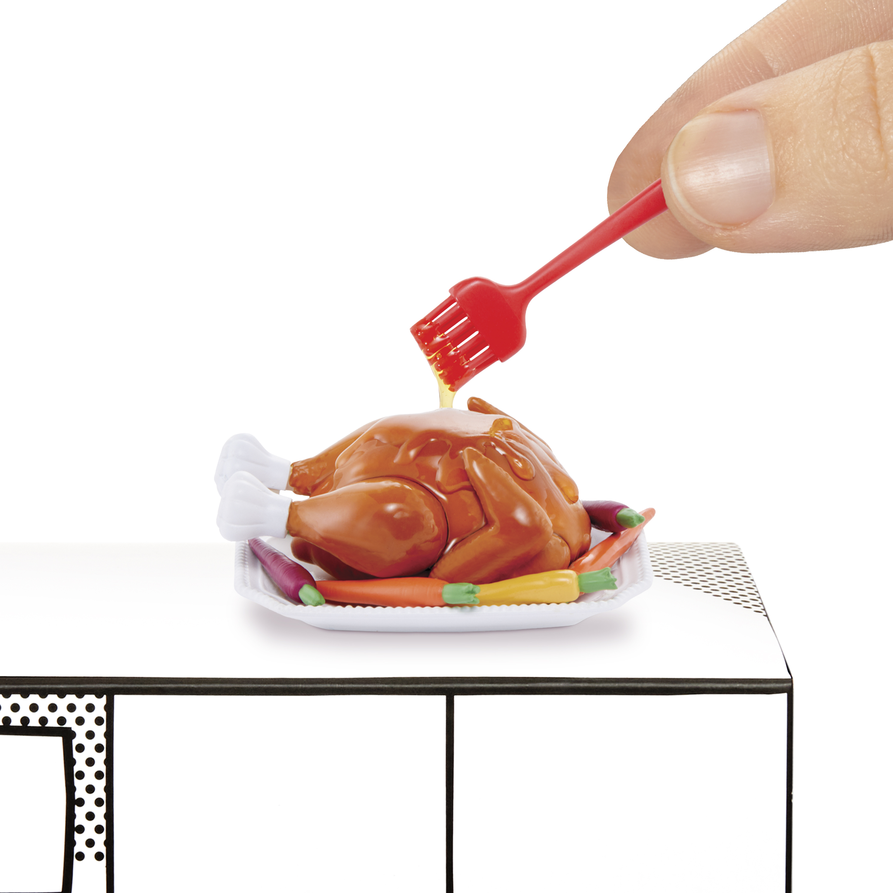Mano con brocha roja, bañando un pavo cocido en un plato blanco con verduras.