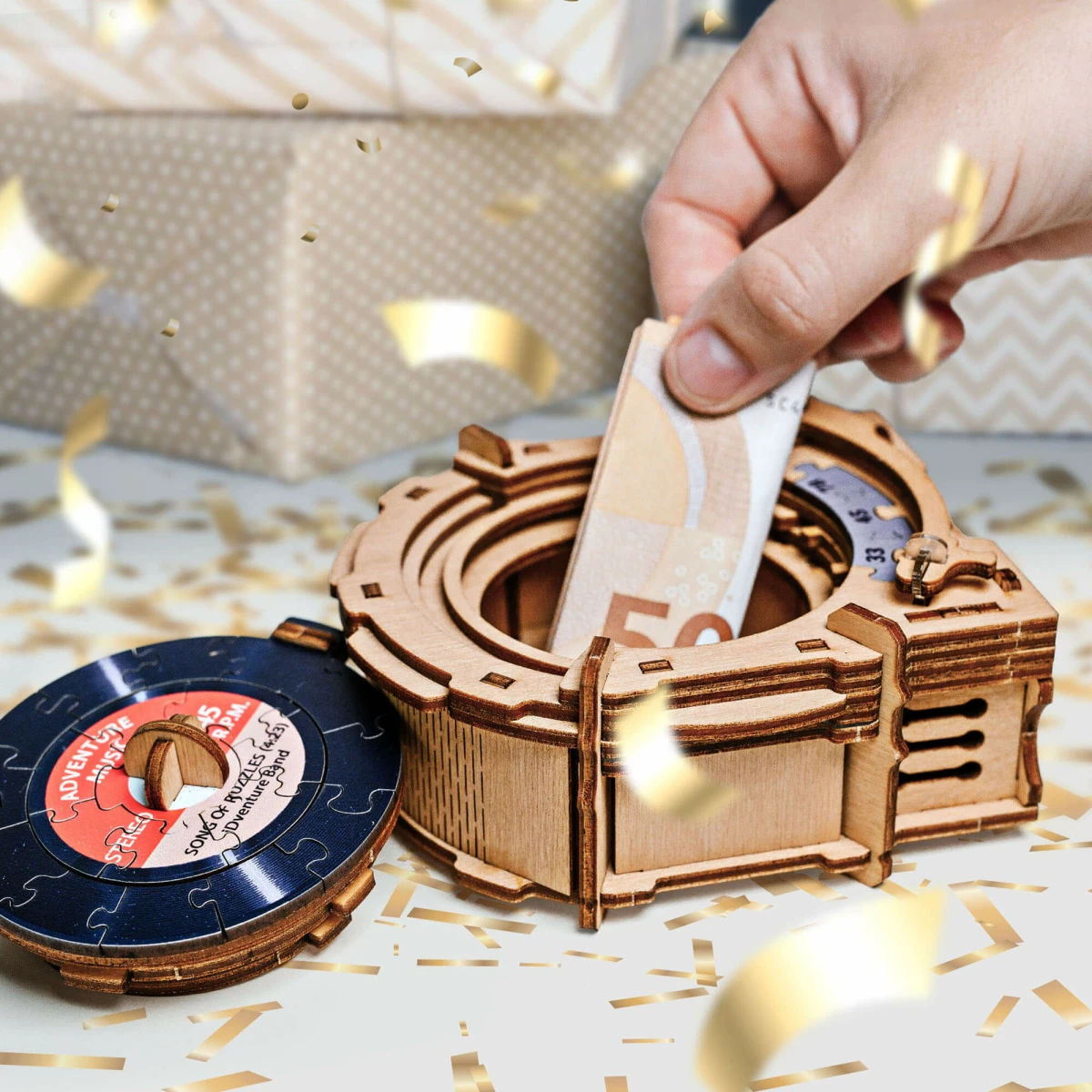 Mano che inserisce denaro in una scatola puzzle di legno con un disco accanto.