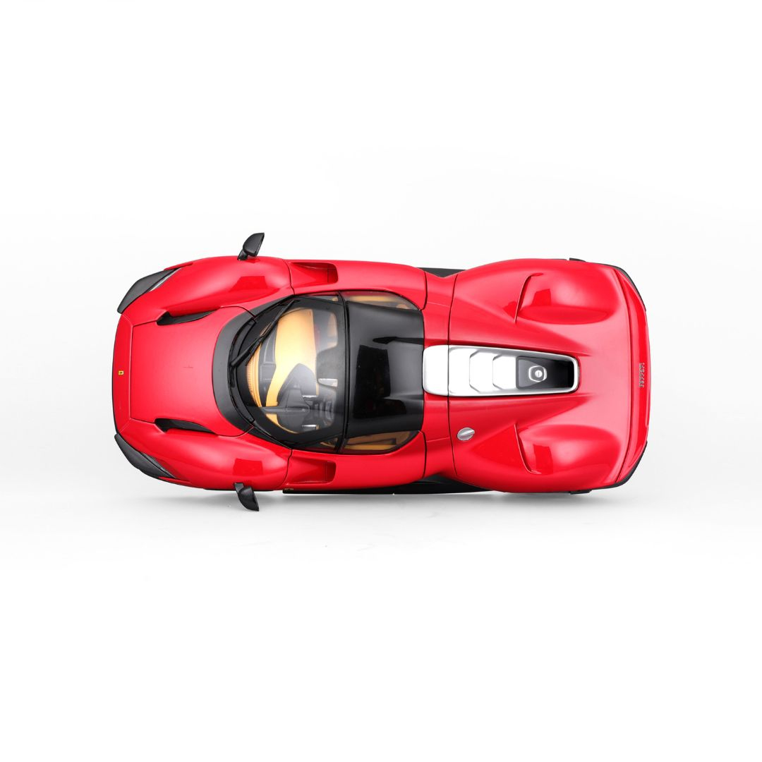 Czerwony model samochodu Ferrari z góry. Czarny dach, żółte wnętrze i srebrne detale. Samochód na białym tle.