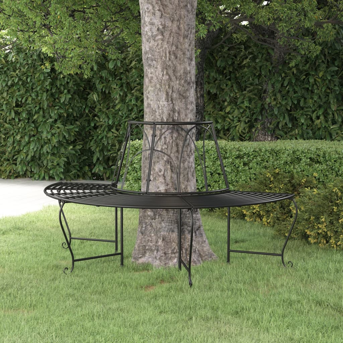Eine schwarze Metallbaum-Bank, die einen Baumstamm in einem grasbewachsenen Bereich mit Büschen umgibt.