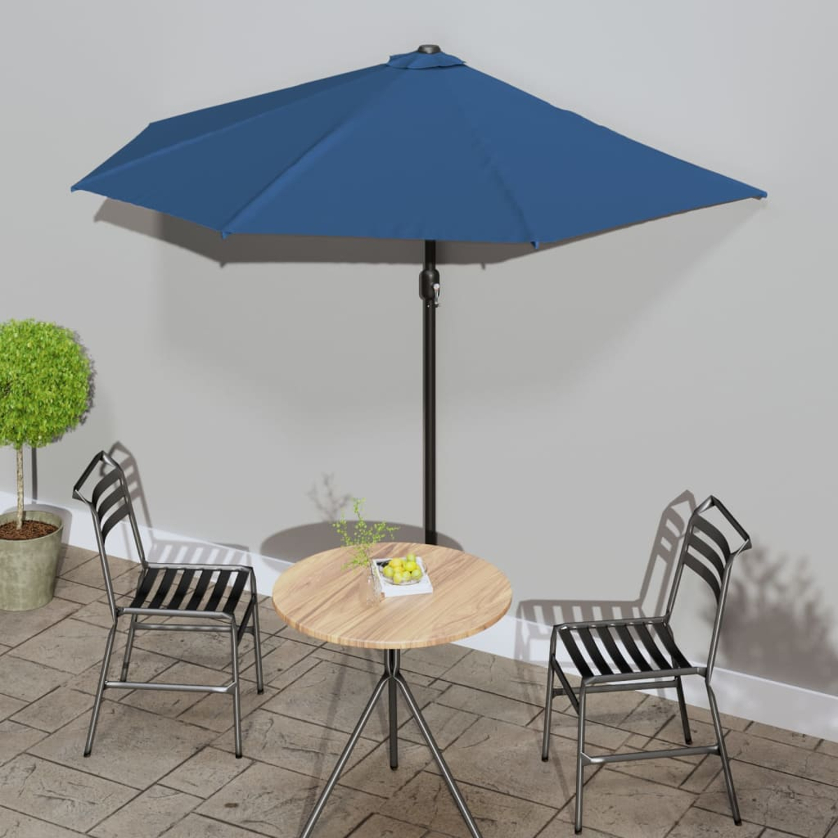 Eine Terrassenszene mit rundem Tisch, Stühlen und blauem Schirm.