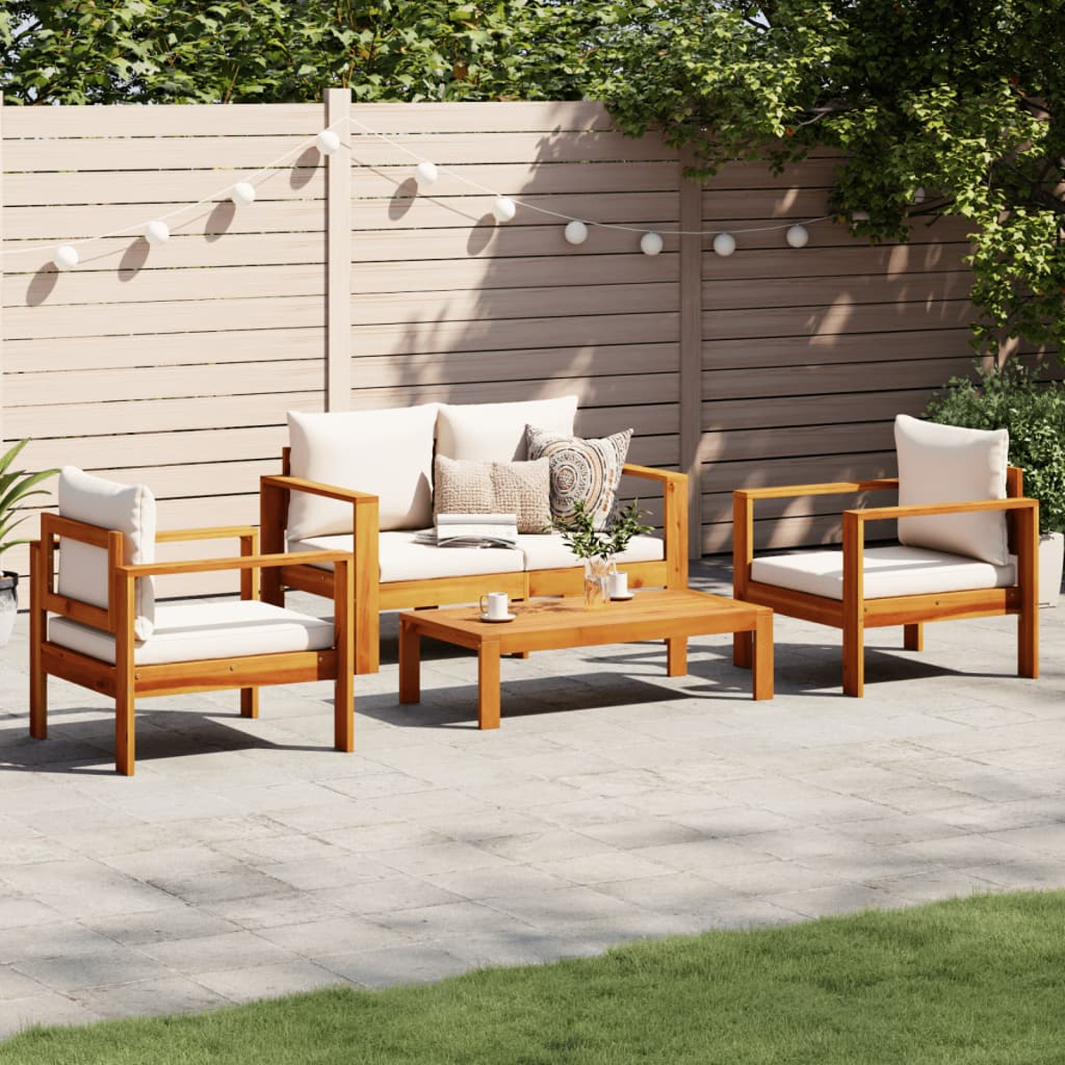 Set di mobili da giardino in legno su un patio, tra cui un divano, due sedie e un tavolino. È soleggiato.