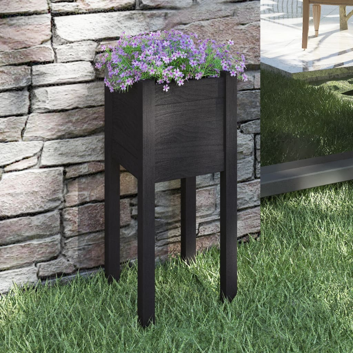 Schwarzer Holzpflanzer mit lila Blumen, auf Gras.