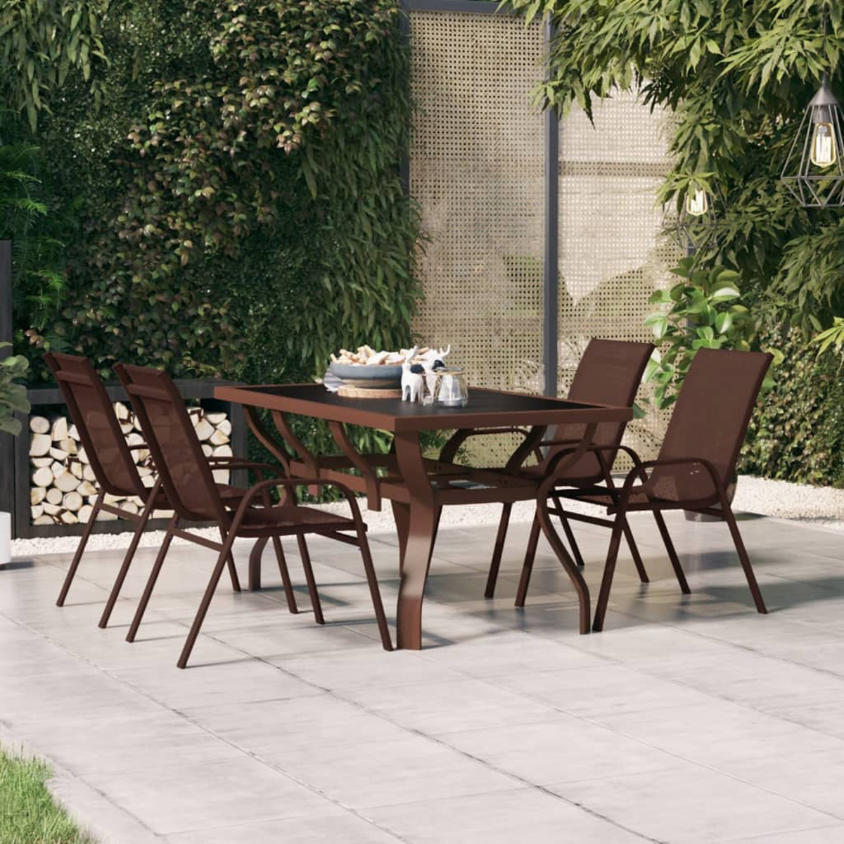 Terrassenset im Freien mit Tisch, Stühlen und Grün. Tisch hat eine schwarze Glasplatte.